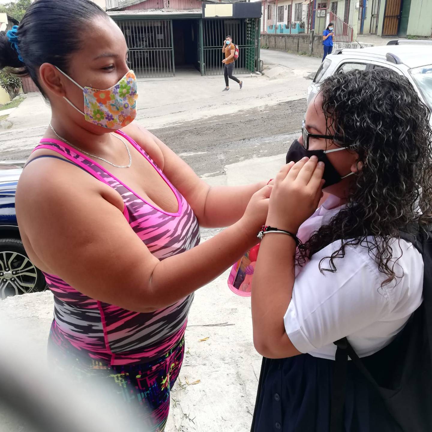 Doña Ileana Acuña Méndez, le acomoda la mascarilla a su hija, Tanisha Molina Acuña, quien entró este 8 de febrero a sexto grado en la escuela Ismael Coto de Alajuelita