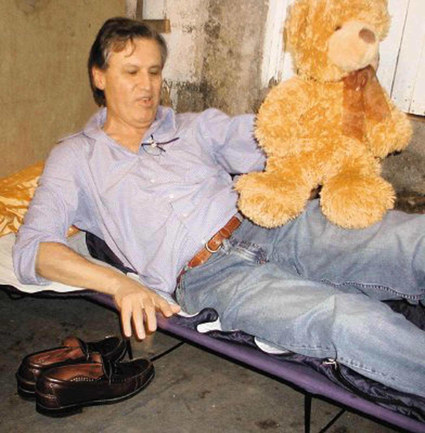 El ministro de vivienda Fernando Zumbado Jiménez con un oso de peluche, tras pasar la noche en un tugurio de Lomas del Río, Pavas, el 29 de mayo del 2007. En la foto, cuando ya estaba en el catre que llevó para dormir.