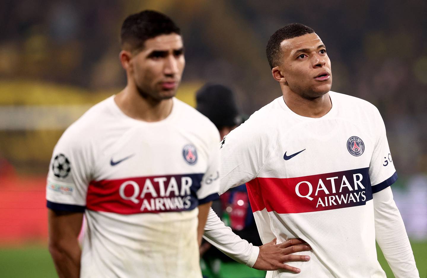 Paris Saint-Germain's French forward #07 Kylian Mbappe (R) and Paris Saint-Germain's Moroccan defender #02 Achraf Hakimi react after the UEFA Champions League group F football match between BVB Borussia Dortmund and Paris Saint-Germain in Dortmund, western Germany, on December 13, 2023. (Photo by FRANCK FIFE / AFP)
