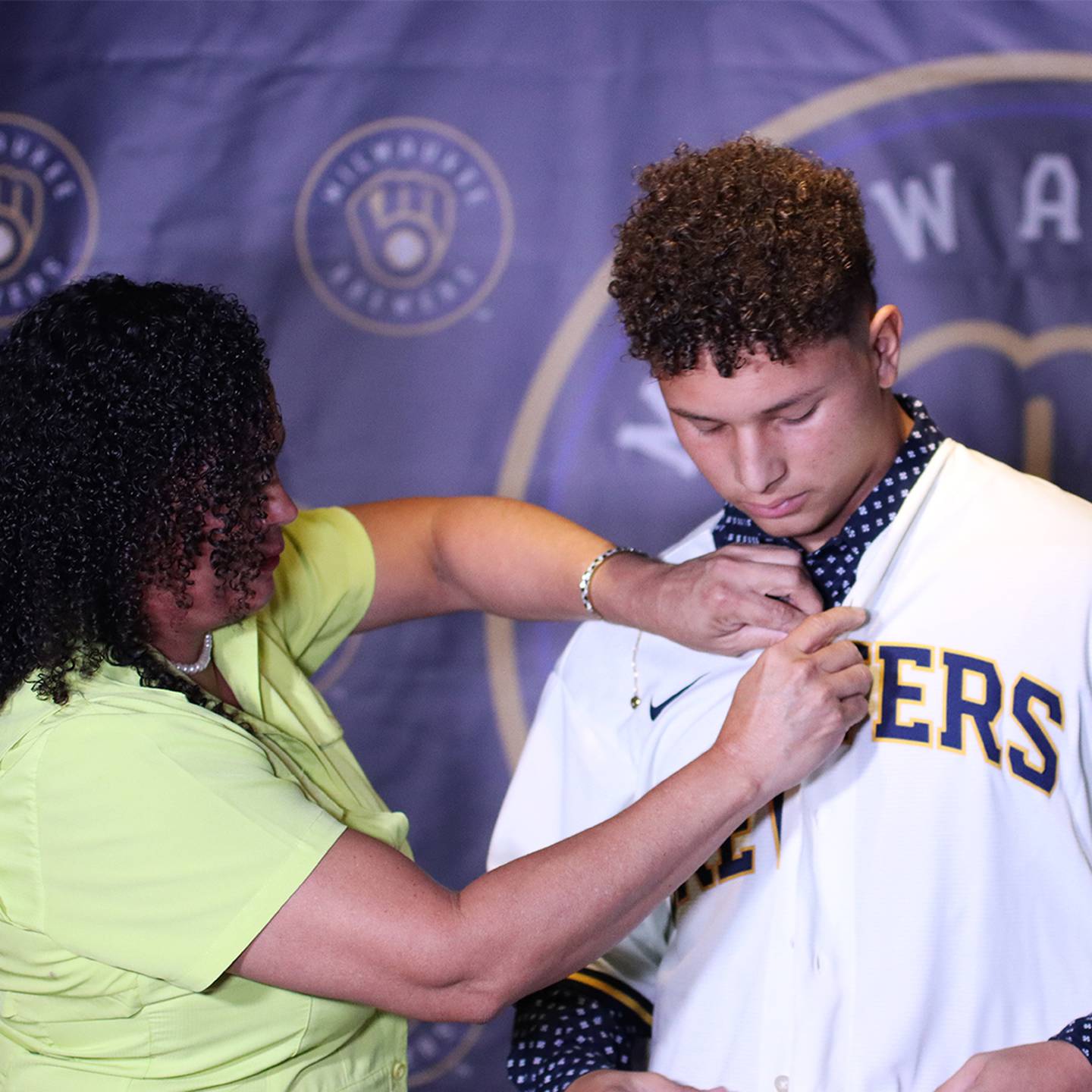 La orgullosa mamá de Ángel González lo vistió con la camiseta de su nuevo equipo, los Cerveceros de Milwaukee. Foto: DT Comunicación.