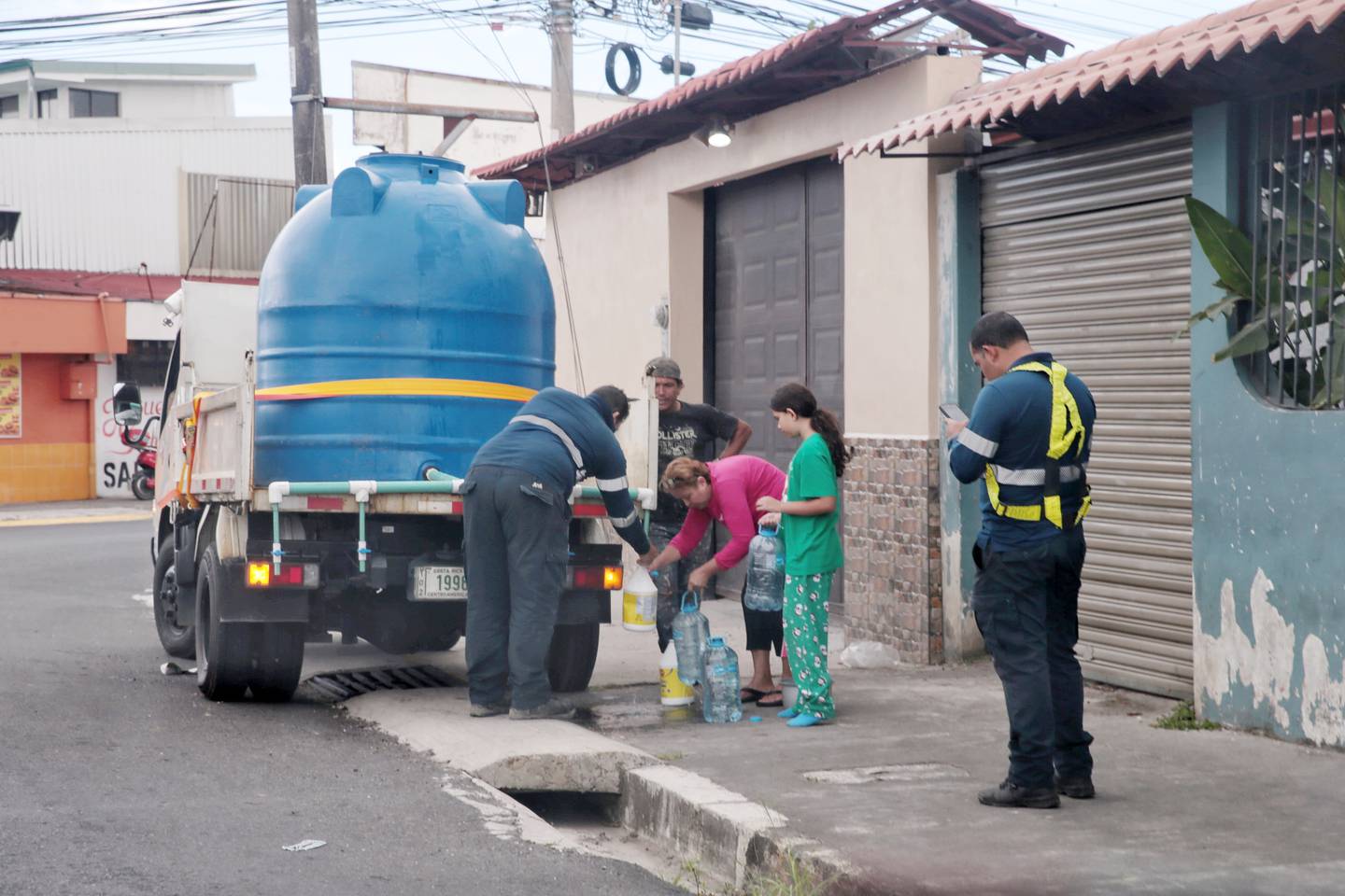 26/01/2024/ Contaminación del agua en Tibás, Moravia Guadalupe afecta a vecinos y comercio, funcionarios del A&A suministran agua en Calle Blancos / foto John Durán