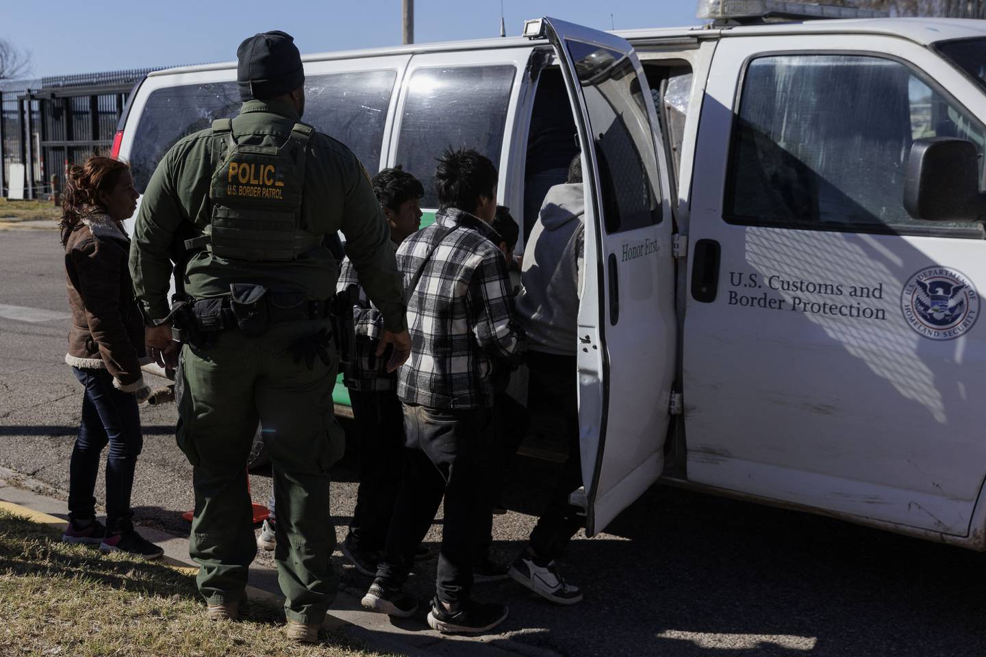 Un agente de la Patrulla Fronteriza guía a los migrantes que cruzaron a Shelby Park hacia una camioneta de la Patrulla Fronteriza para ser llevados a un centro de procesamiento en Eagle Pass, Texas.