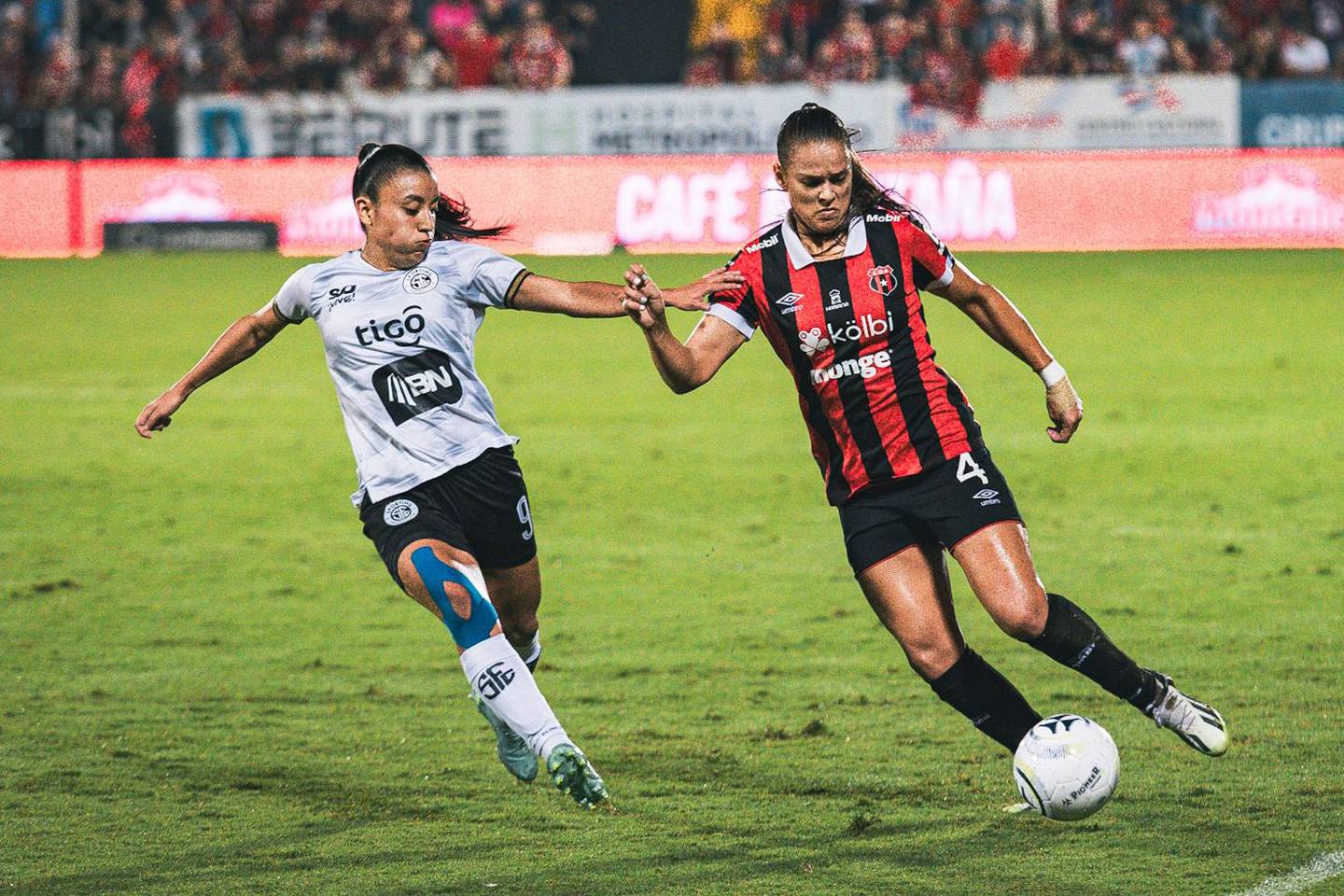 Paula Coto conduce el balón ante la marca de Yerling Ovares, en la final femenina entre Liga Deportiva Alajuelense y Sporting.