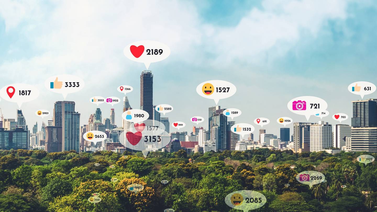 Emojis y reacciones en redes sociales encima de una ciudad