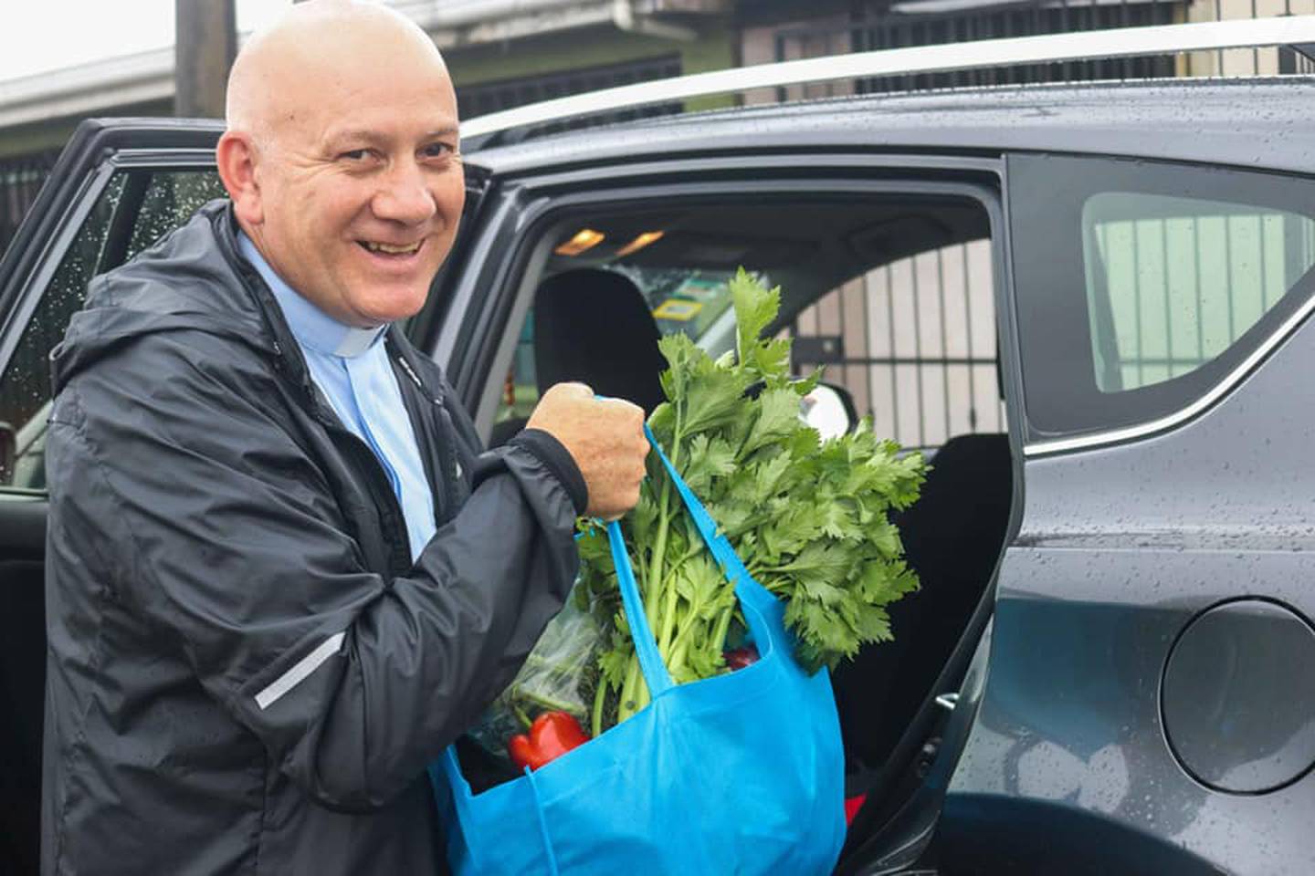 Monseñor Mario Quirós, obispo de Cartago, ayuda a repartir verduras