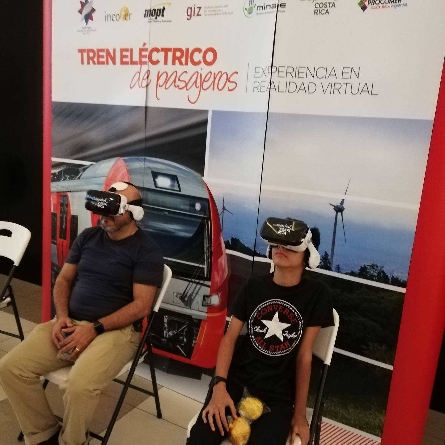 Realidad Virtual para ver lo que será el Tren Eléctrico entre Alajuela y Cartago. En la foto don Vinicio Mora comparte la realidad virtual con su hijo Esteban de 12 años.