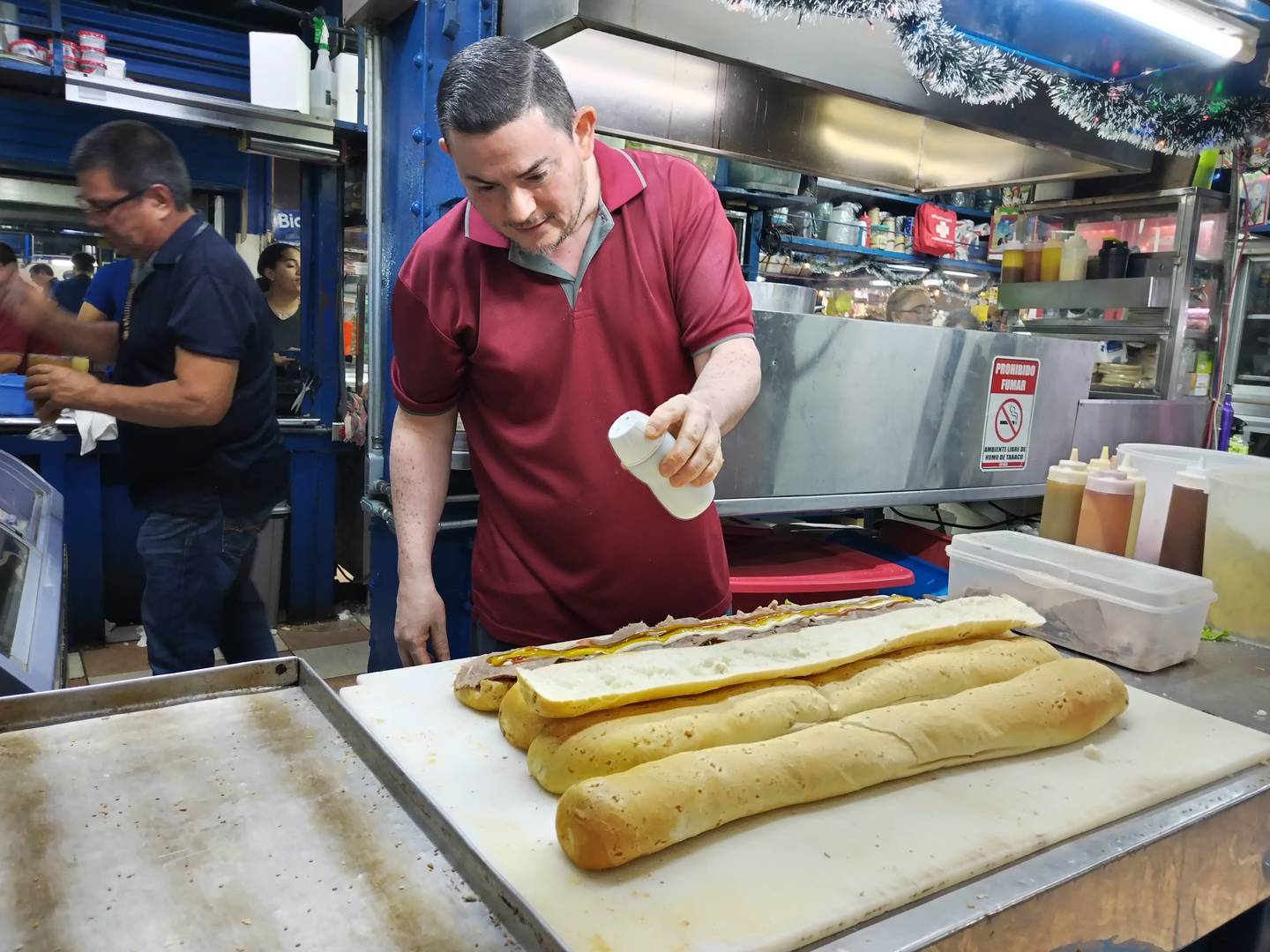 José Alberto Navarro Zeledón, quien es de Birrisito de Cartago, tiene 50 años, es casado y tiene 4 hijos, trabaja en la soda Río de Janeiro en el Mercado de Cartago y hace 500 sándwiches por día, su récord es de 900 en un solo día.