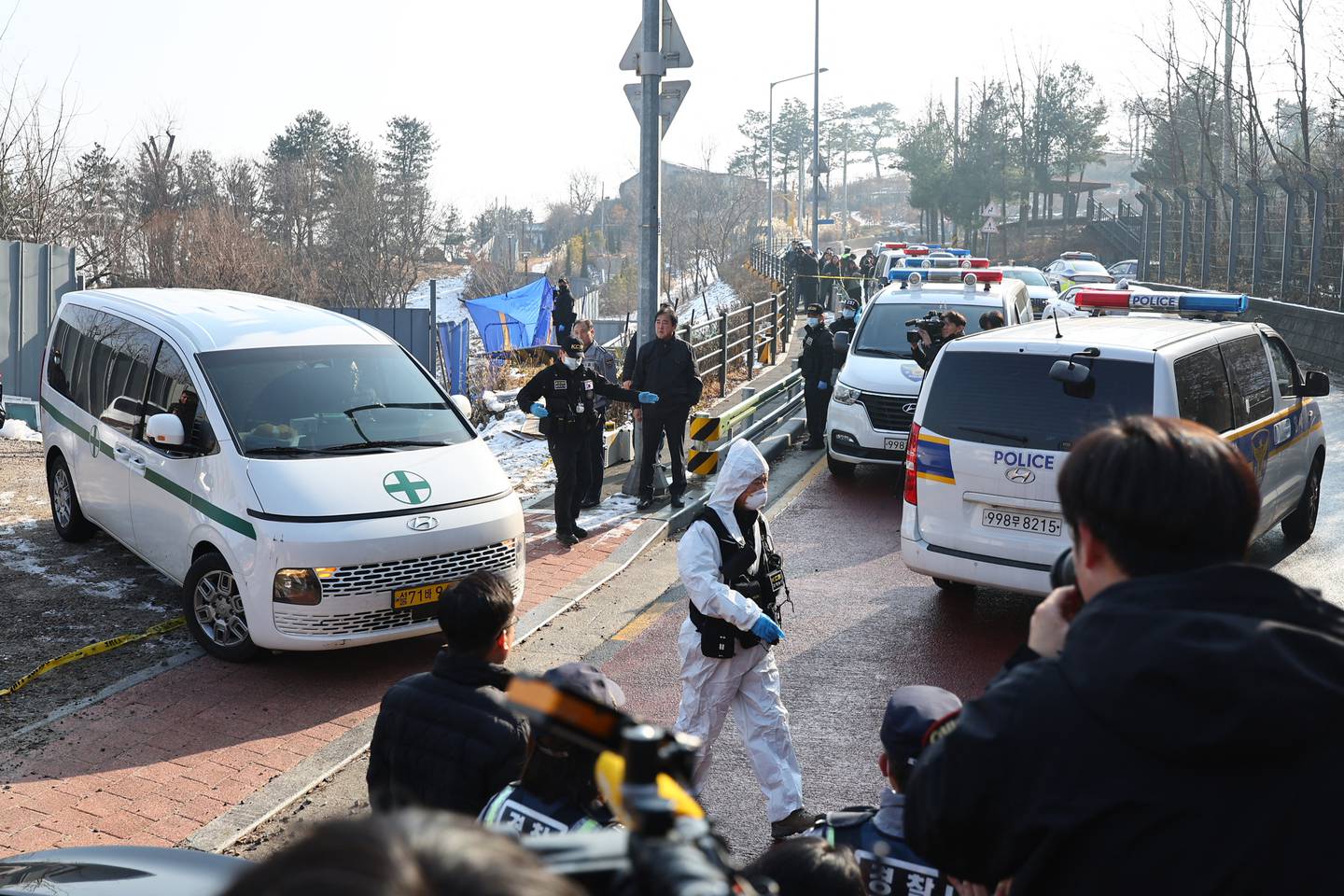 Una ambulancia (izq.) que transporta el cuerpo del actor surcoreano Lee Sun-kyun sale de un parque en el centro de Seúl.