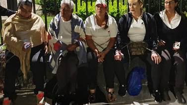 Mujeres taxistas se encadenan a verjas de Casa Presidencial