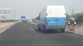(Video) Ciclista viaja en chancletas a 100 km/h agarrado de los faros de vehículo
