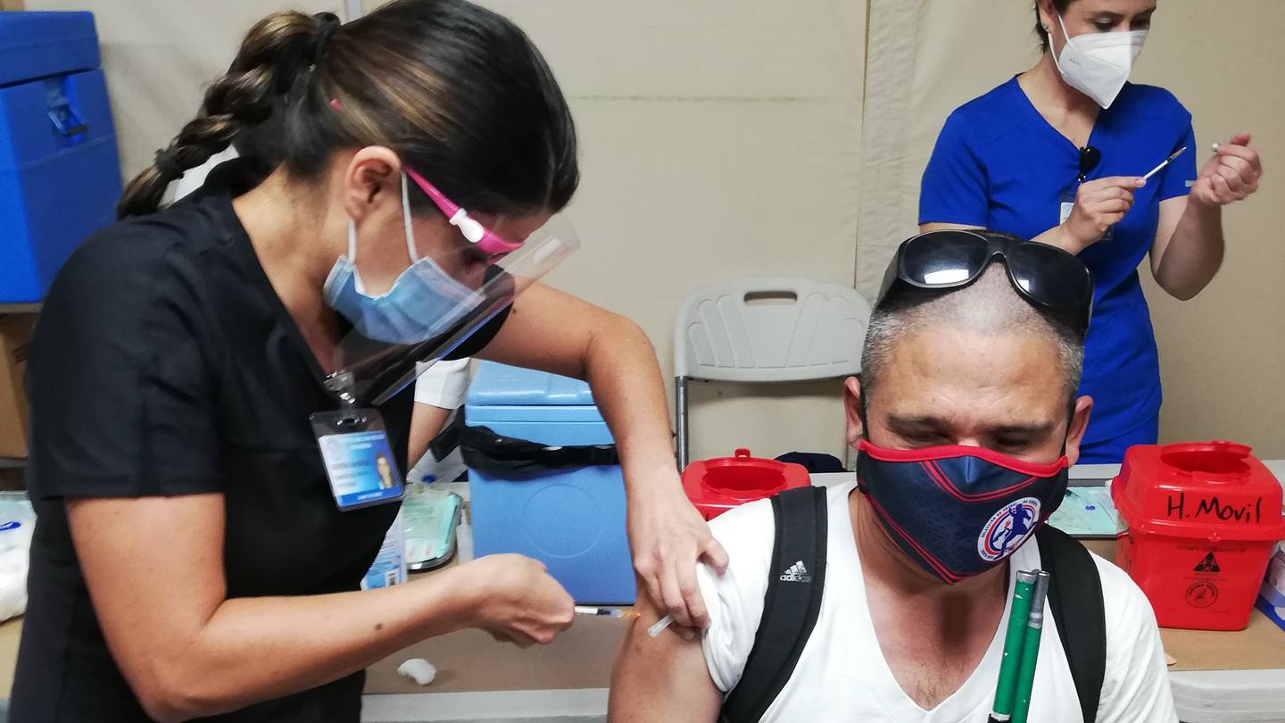 La enfermera del Hospital San Juan de Dios Keren González vacuna a Michael Mora Solís, seleccionado nacional de fútbol de no videntes