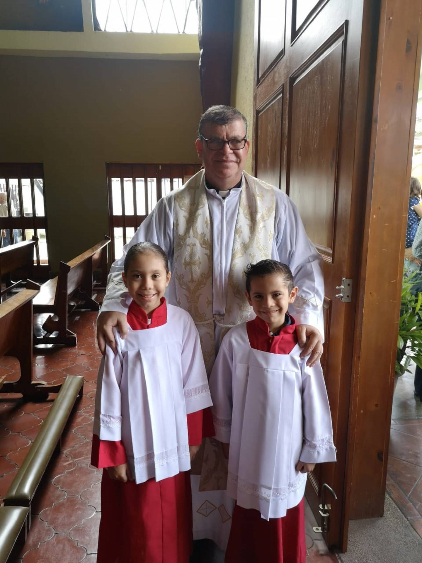 Evan Arroyo Arguedas es monaguillo en la parroquia San Rafael Arcángel de San Rafael Arriba de Desamparados y tiene cuatro días de “hacer teletrabajo”. En la foto con su hermana Krysia y el padre Jorge González (Jito).