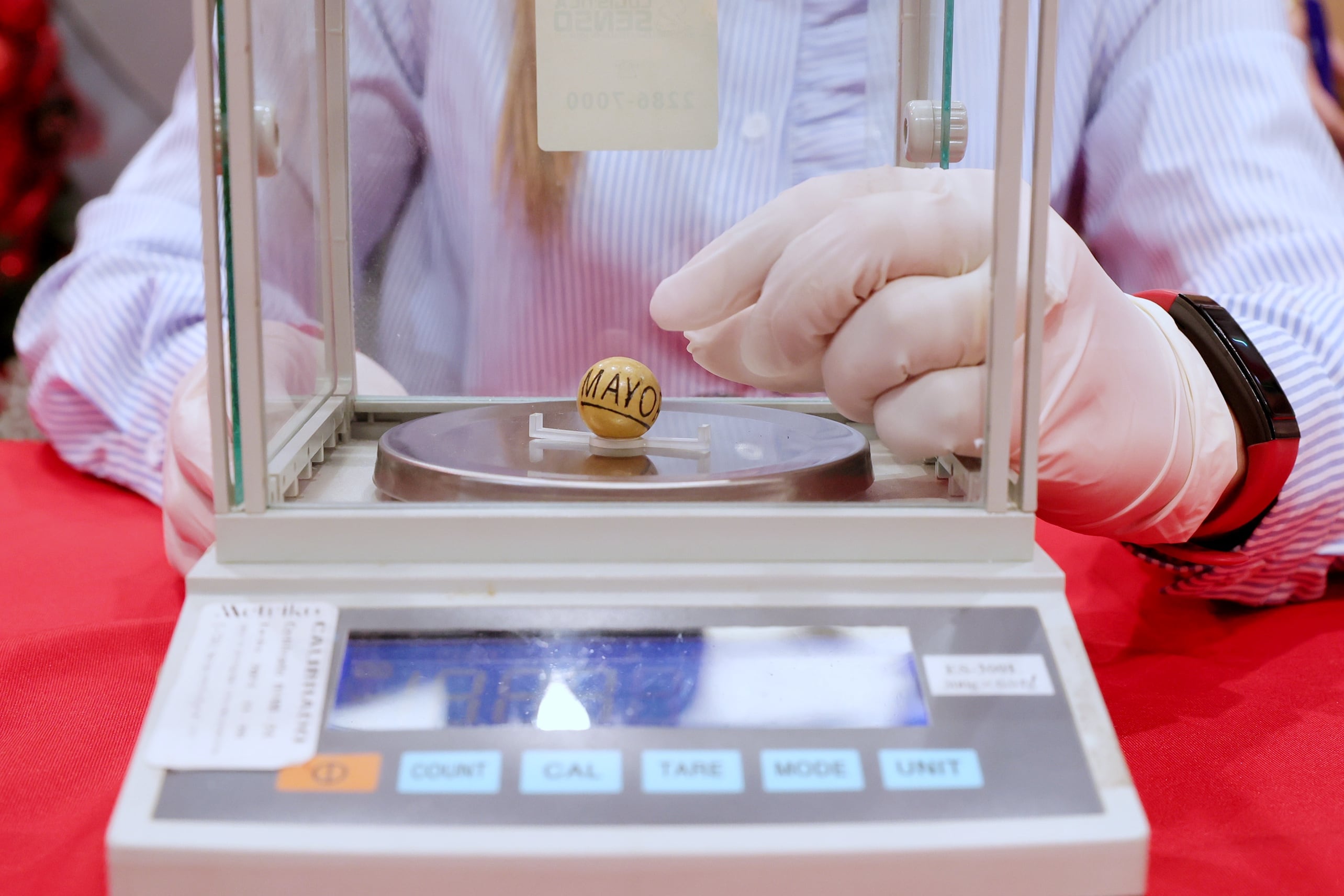 Funcionarios de la Junta de Protección Social JPS pesan las bolitas del sorteo del Gordo Navideño 2024