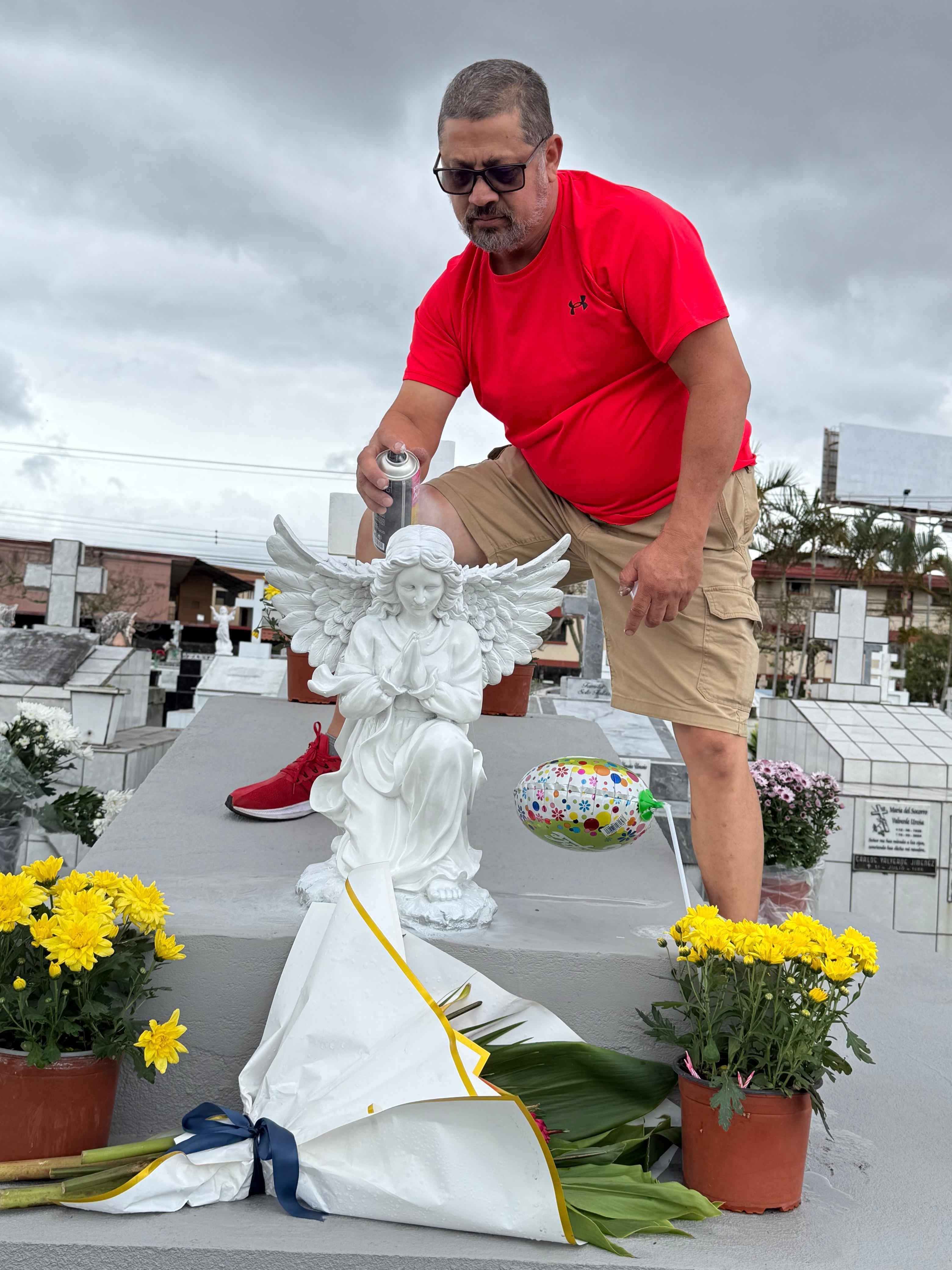El sábado 15 de agosto del 2026, Día de las Madres, realizamos un recorrido por tres cementerios en San José: el Obreros, el General y el Municipal de Desamparados. En la foto, don Jorge Blanco, esposo de doña Deborah, le echa pintura blanca al ángel de la tumba de su suegra.