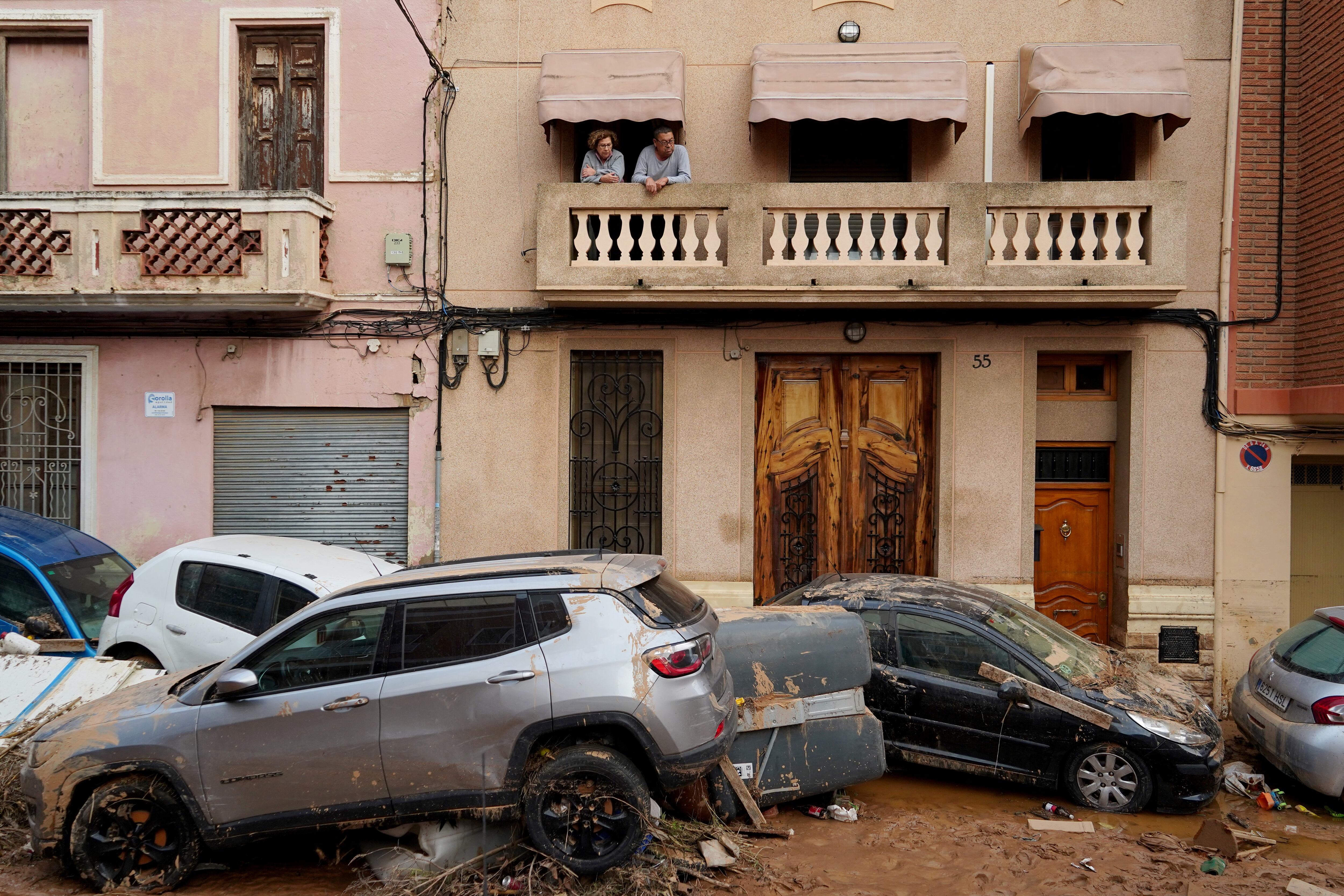Residentes observan desde su balcón los autos apilados tras las mortales inundaciones repentinas en La Torre, al sur de Valencia, España. Hasta ahora, contabilizan más de 150 personas fallecidas. (Foto: AFP)