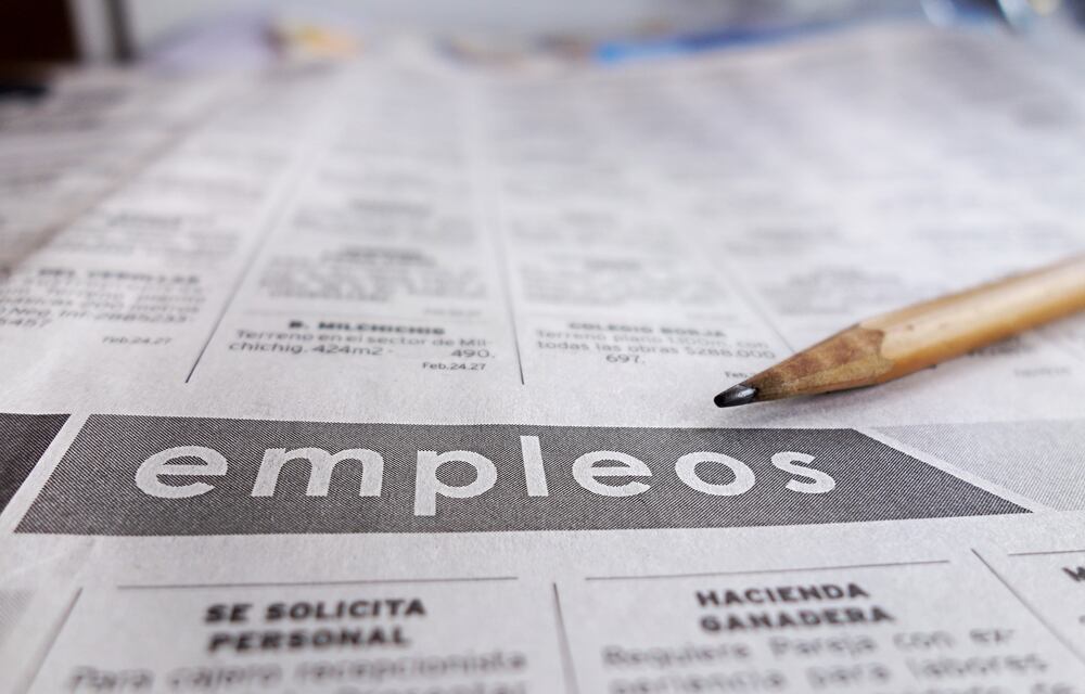 Primer plano de un periódico en la sección de empleos con un lápiz sobre la página, simbolizando la búsqueda de trabajo y oportunidades laborales.
