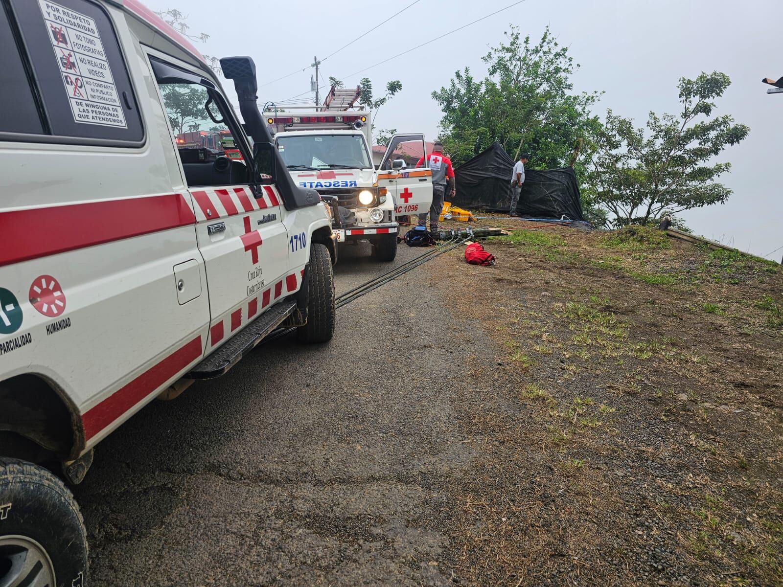 Un accidente de tránsito, se ven carros de Cruz Roja, en un extremo de la vía hay árboles.
