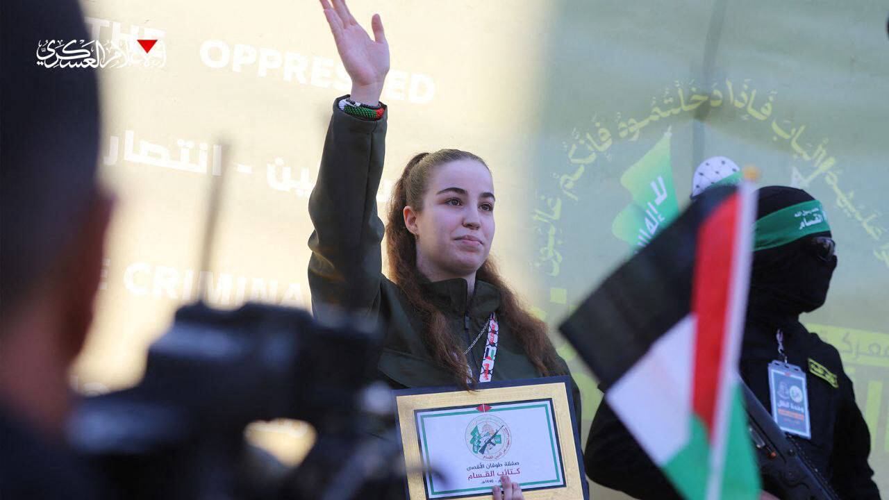 Esta imagen difundida por la Oficina de Medios de Comunicación de Hamás el 30 de enero de 2025 muestra a la soldado israelí Agam Berger (centro), que estuvo secuestrada en Gaza desde octubre de 2023, saludando mientras militantes palestinos de Hamás la escoltan hasta un escenario antes de entregarla a un equipo de la Cruz Roja.