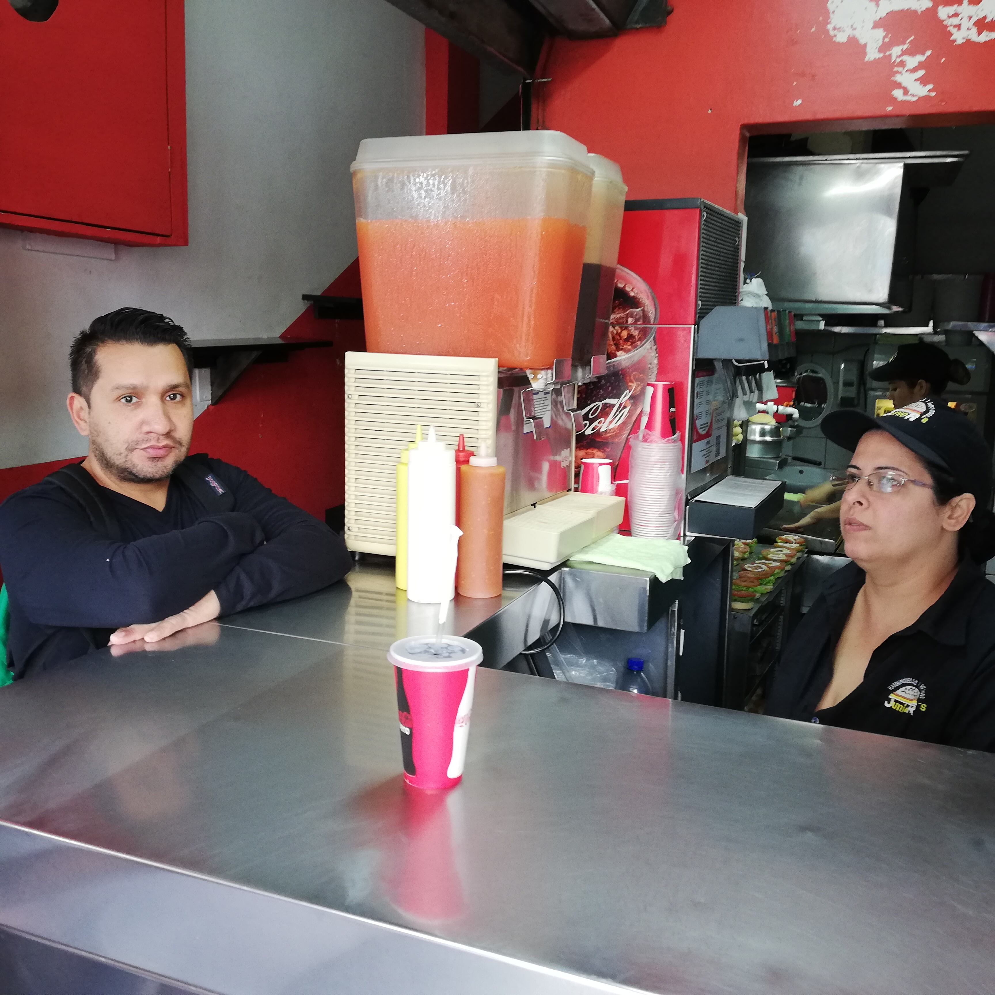 una ventanita llamada Junior’s que va a cumplir 45 años de existencia y desde ya lo celebra de la mejor forma, vendiendo su especialidad, hamburguesas. En la foto Margarita Ruiz atiende el pedido de Freddy Rosales.