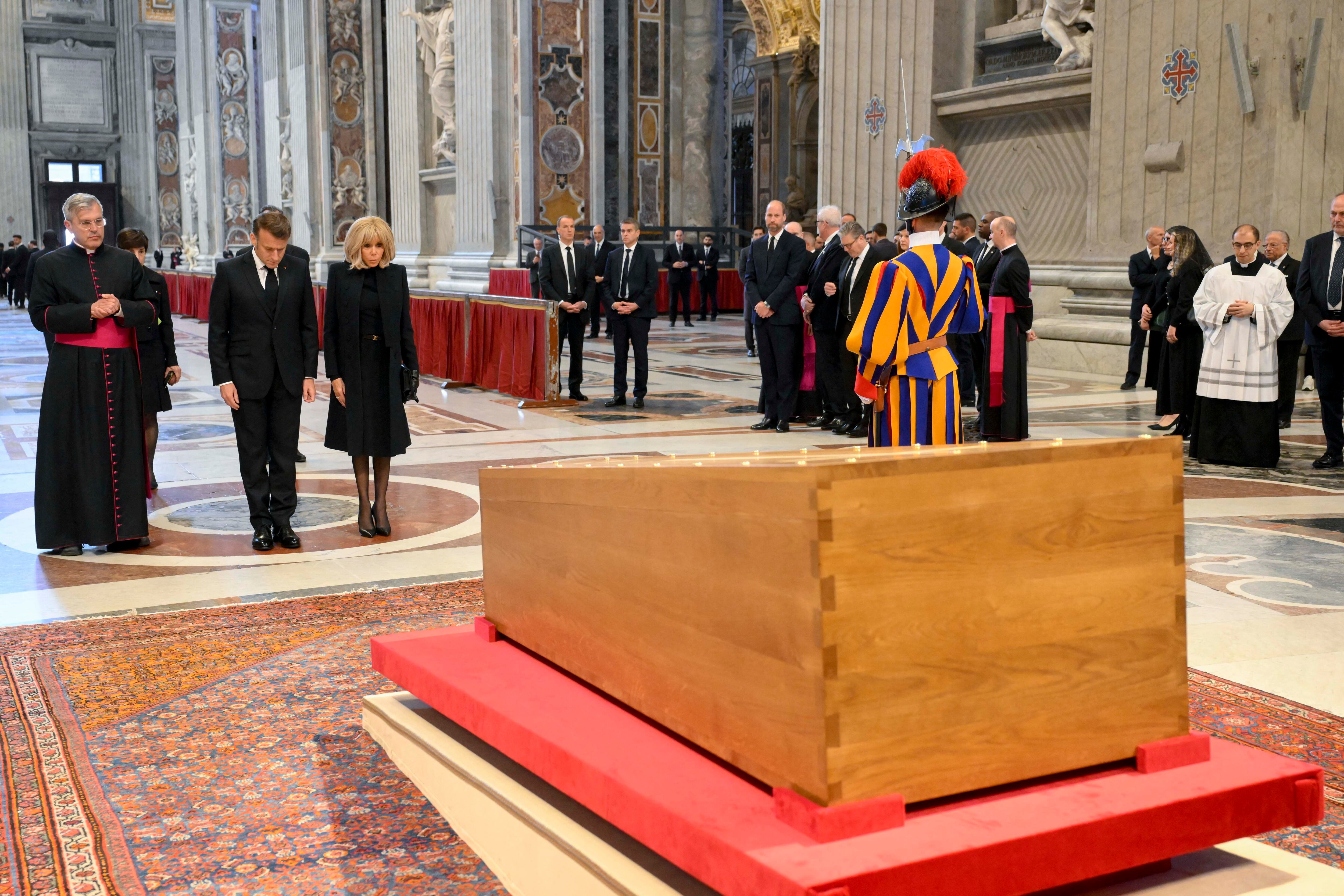 This photo taken and handout on April 26, 2025 by The Vatican Media shows France's President Emmanuel Macron and his wife Brigitte paying their respects to Pope Francis before the funeral ceremony in The Vatican. (Photo by Francesco Sforza / VATICAN MEDIA / AFP) / RESTRICTED TO EDITORIAL USE - MANDATORY CREDIT "AFP PHOTO / VATICAN MEDIA" - NO MARKETING - NO ADVERTISING CAMPAIGNS - DISTRIBUTED AS A SERVICE TO CLIENTS