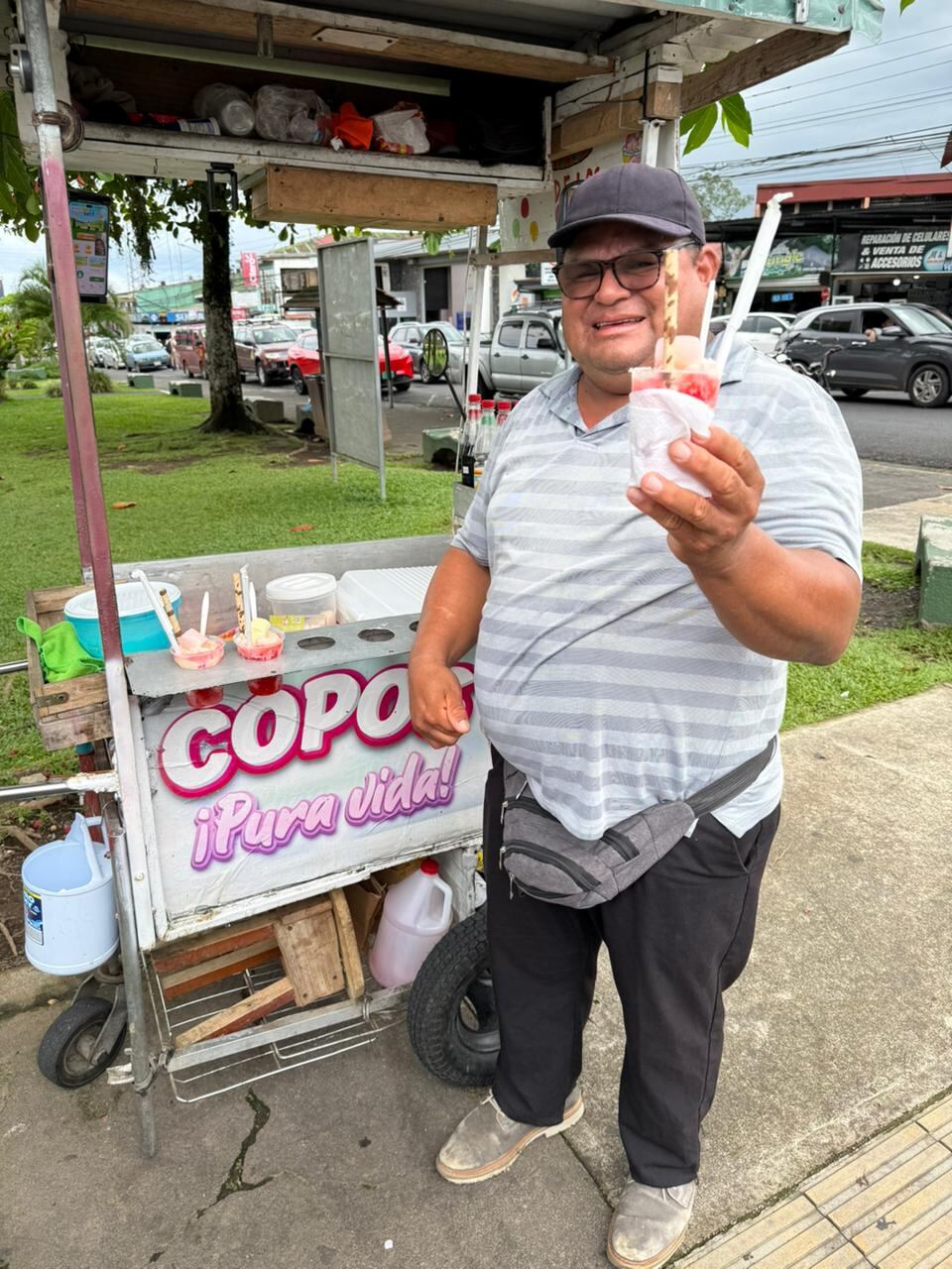 Las personas buscan dónde esconderse cuando cae un aguacero en La Fortuna de San Carlos, pero el nicaragüense, Antonio Padilla Madriz, más bien sonríe y le agradece a Dios porque así venderá más copos