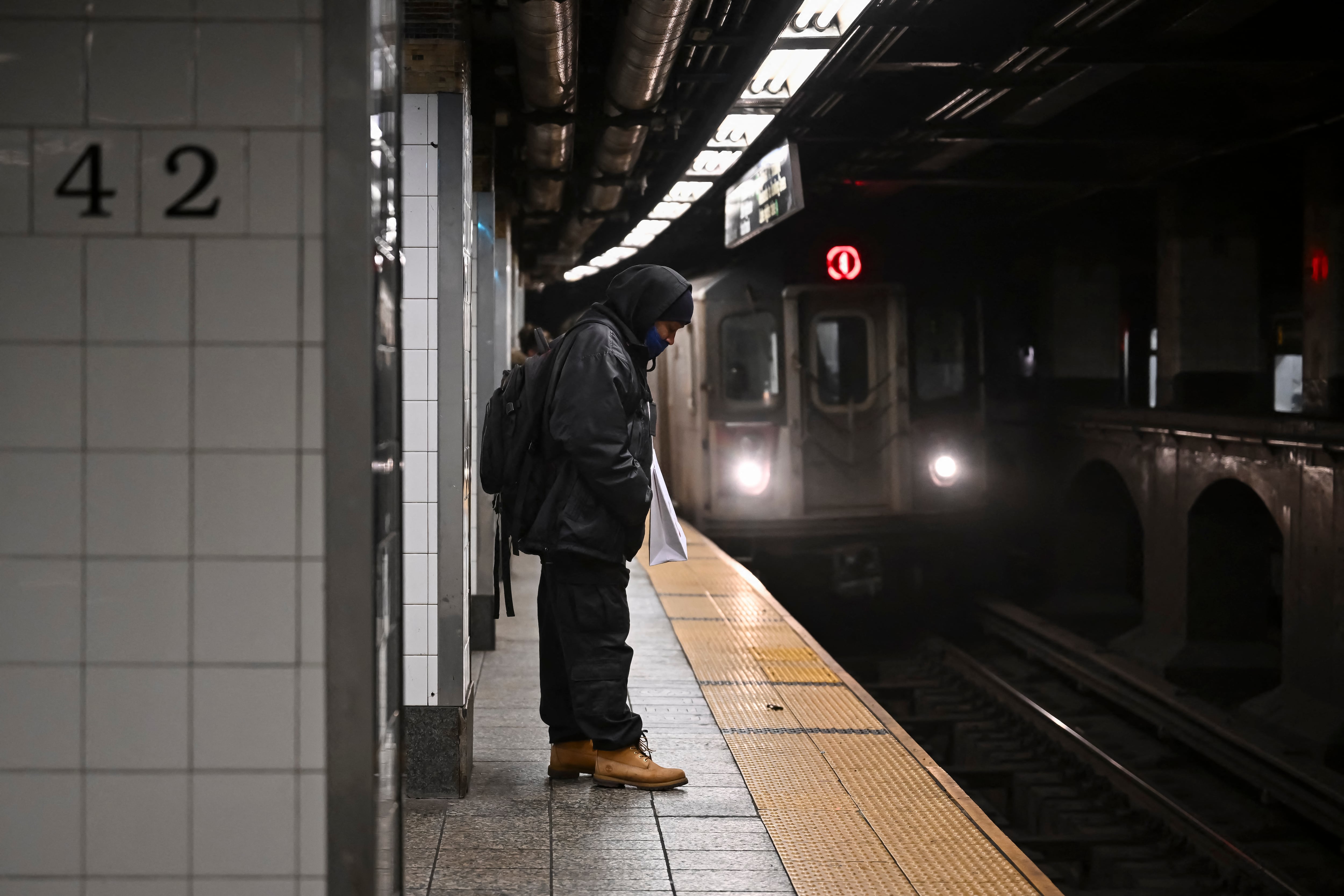 A person waits on a subway platform as a train approaches the station in New York City on February 3, 2025. Joseph Lynskey was quietly waiting for a New York subway train on New Year's Eve when he was pushed from behind onto the tracks as a train pulled into the station. "I knew instantly... that somebody had pushed me and tried to kill me," the music producer told AFP. (Photo by ANGELA WEISS / AFP)