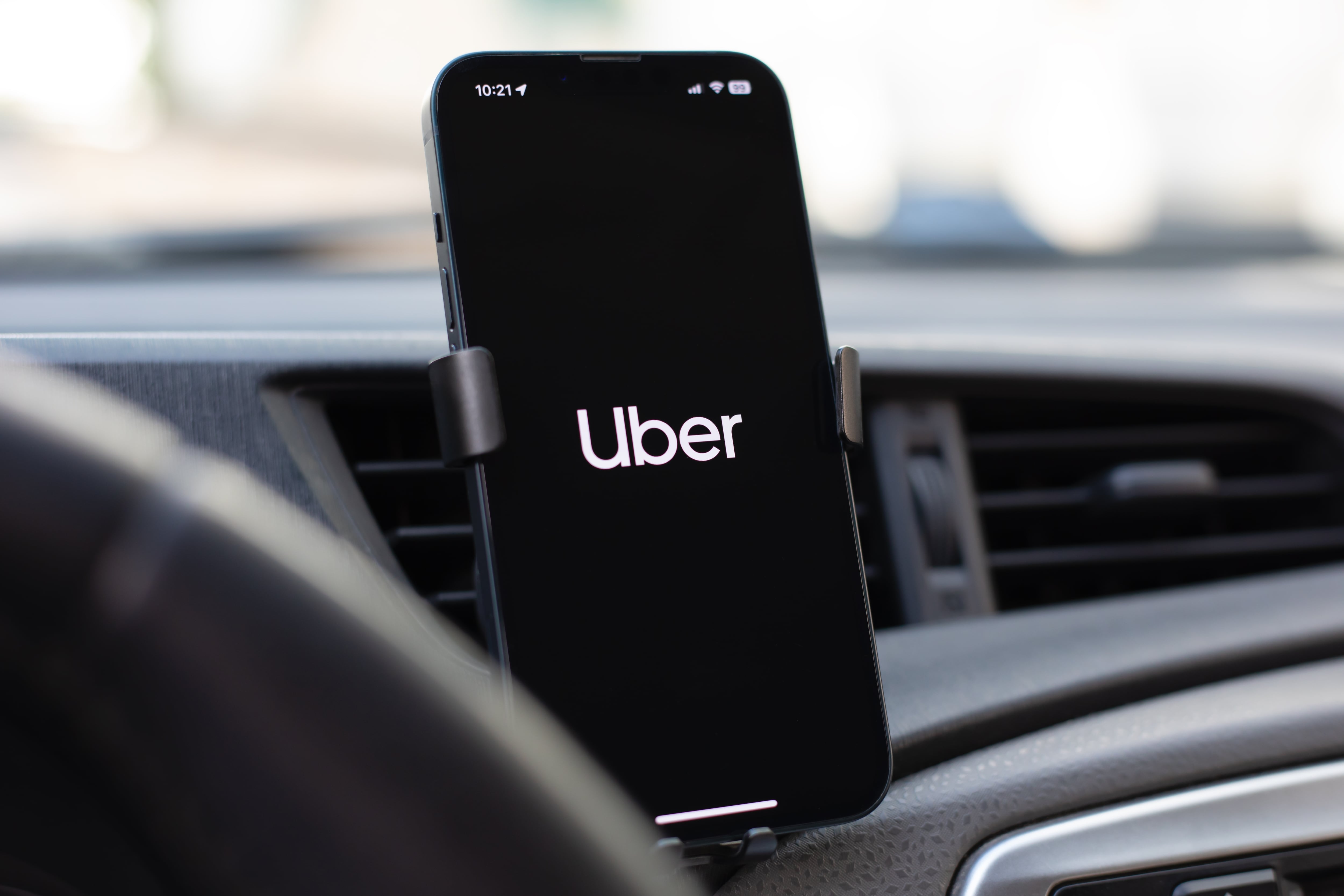 Foto de un celular con la aplicación de Uber en un soporte de carro