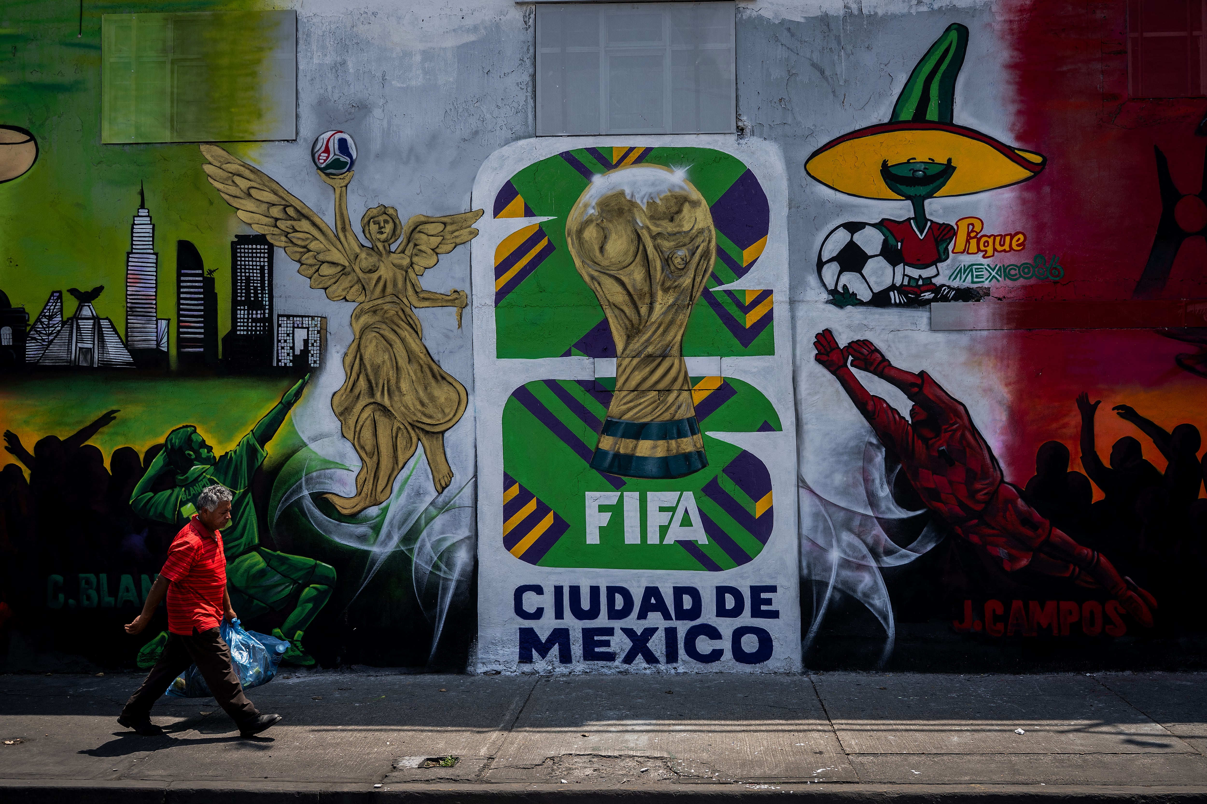 Un hombre pasa junto a un mural sobre la Copa Mundial de la FIFA 2026 en Ciudad de México el 14 de julio de 2025. La Copa Mundial de la FIFA 2026 se disputará en México, Estados Unidos y Canadá del 11 de junio al 19 de julio de 2026. La competición dará comienzo con el partido inaugural en el emblemático Estadio Azteca de Ciudad de México el 11 de junio. (Foto de Carl DE SOUZA / AFP)