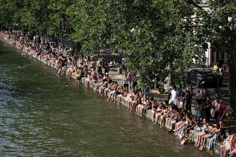 Bañistas toman sol en las orillas del Canal Saint-Martin mientras Francia atraviesa una ola de calor, en París.