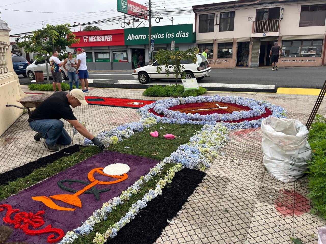 La celebración de Corpus Christi, desde la madrugada del domingo 7 de junio decenas de vecinos trabajaban contra reloj para convertir las calles alrededor del templo de San Rafael Arcángel de Heredia en una verdadera alfombra de fe, color y tradición. Mauricio Campos fue uno de ellos.