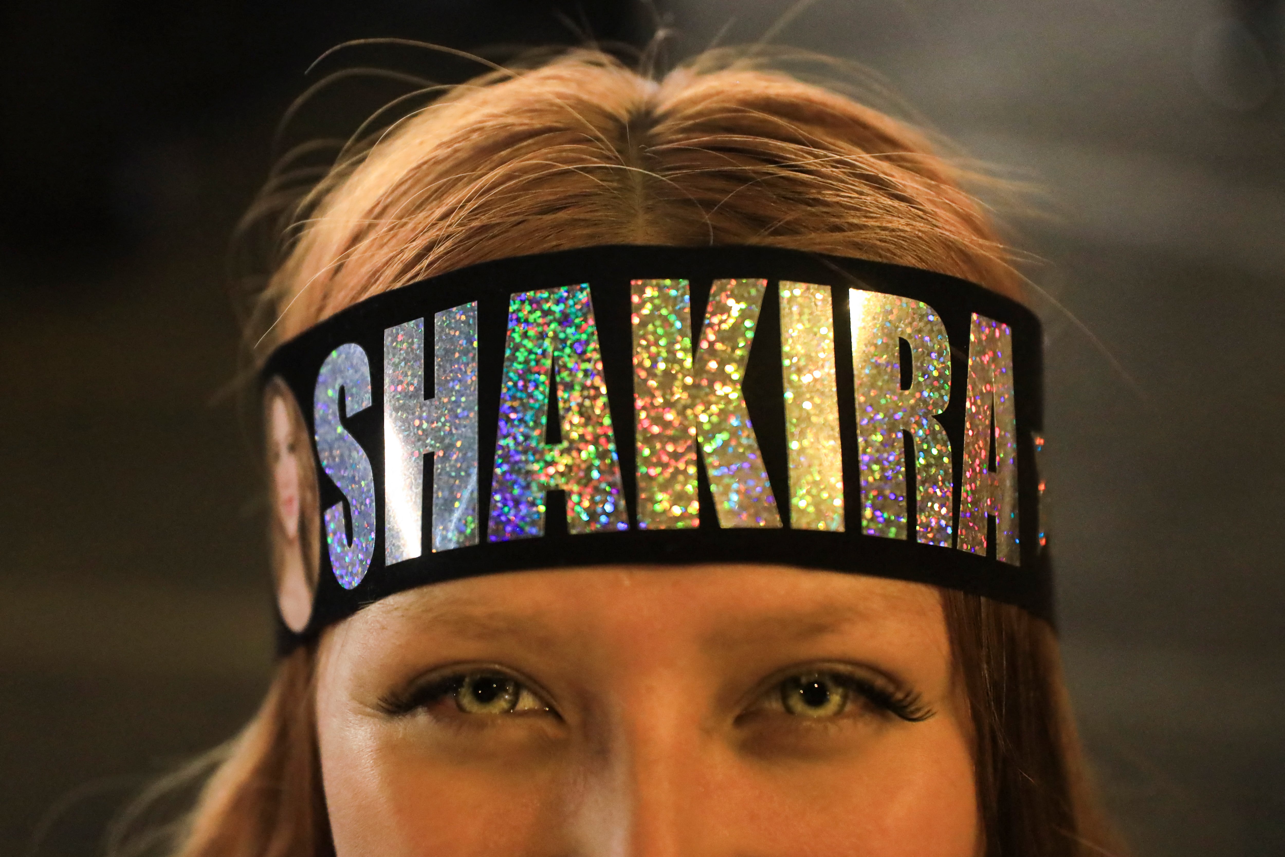 Una fan posa para una fotografía frente a la clínica donde se encuentra hospitalizada la cantante colombiana Shakira.