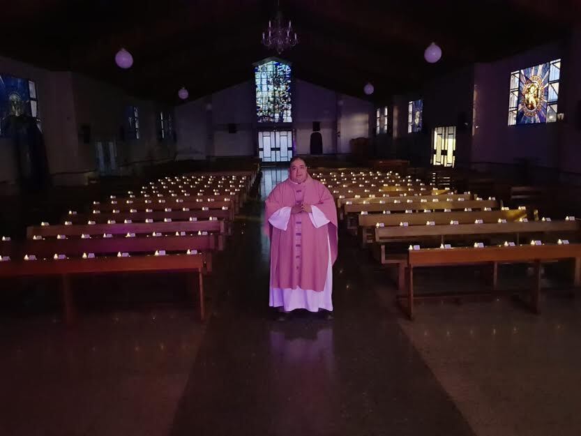 Padre Toto da misa con bancas llenas de foto