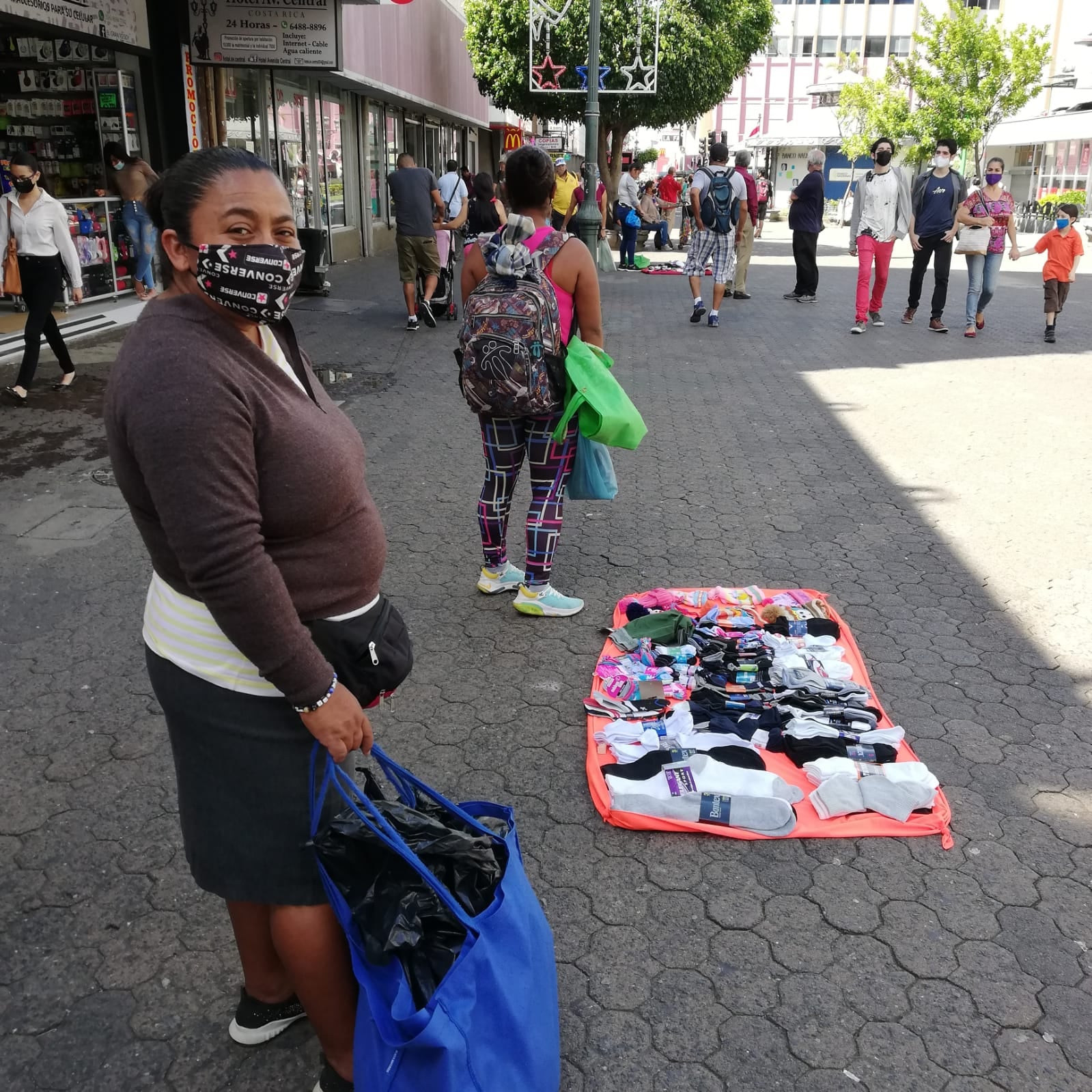 Los vendedores ambulantes de San José la están viendo horrible para conseguir qué vender y tener variedad por la crisis de los contenedores. En la foto doña Cruz Quintanilla se alista para poner su mercadería en venta en el bulevar de la avenida central de San José