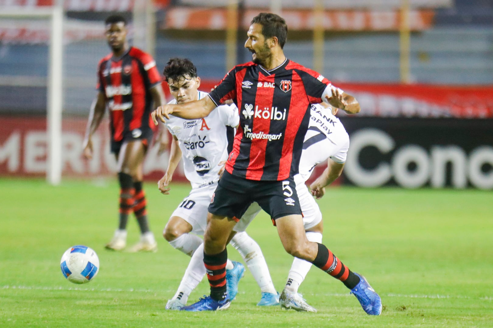 Celso Borges custodia el balón, controlando a Leonardo Menjívar, en el partido entre Alianza y Liga Deportiva Alajuelense.