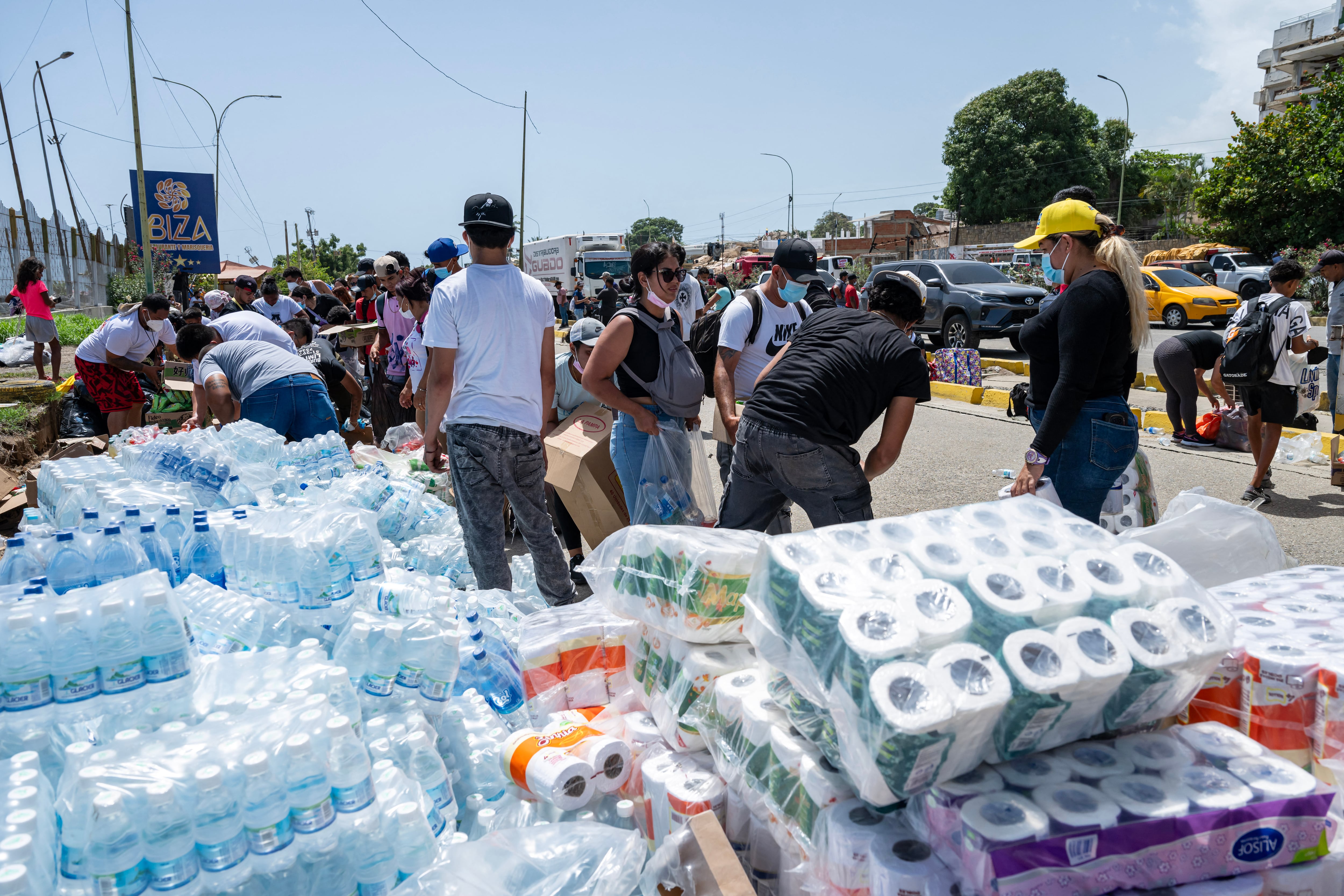 Damnificados reciben ayuda humanitaria esencial en un centro de distribución improvisado tras los devastadores terremotos.