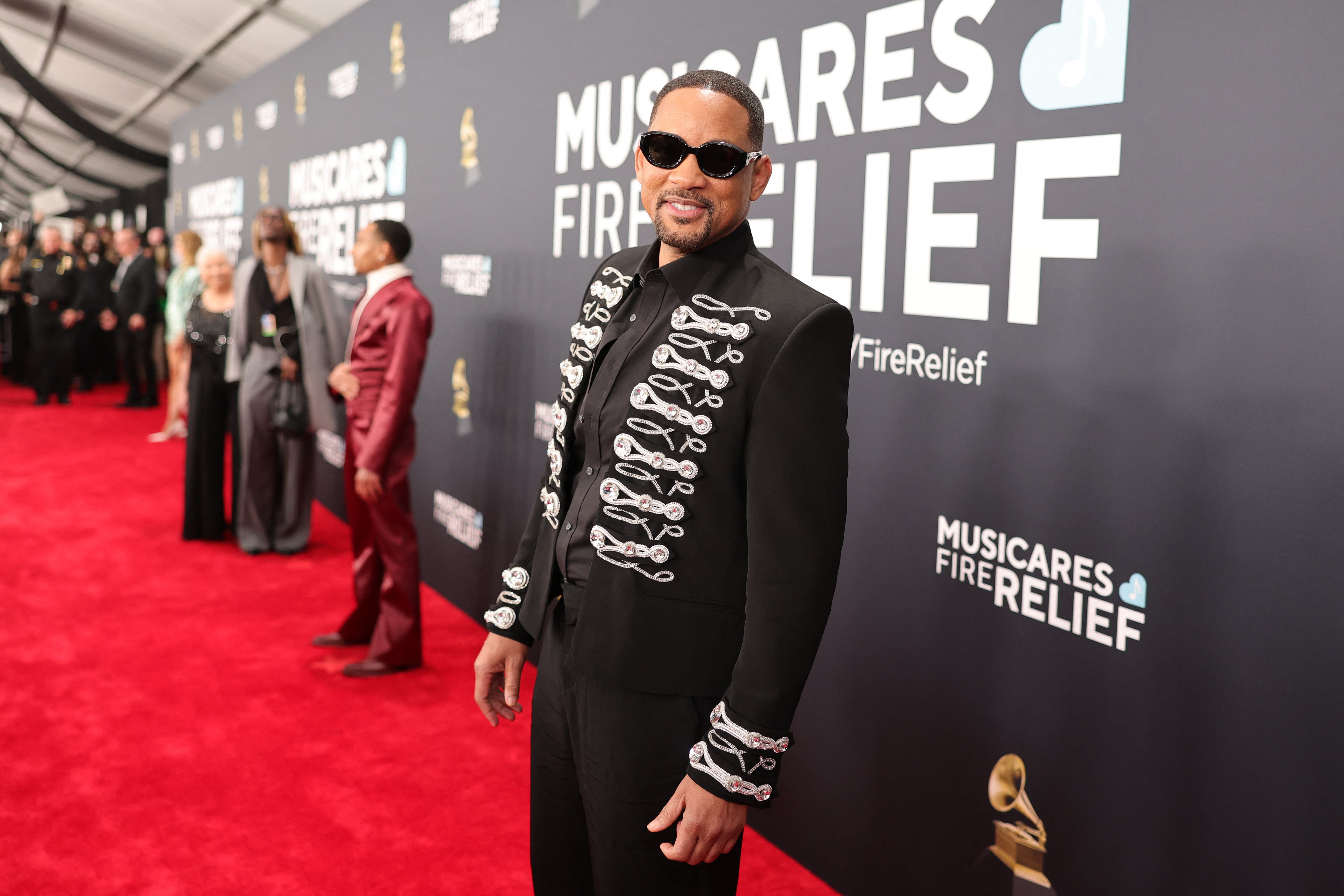 Will Smith en la alfombra roja de los premios Grammy con un traje negro.