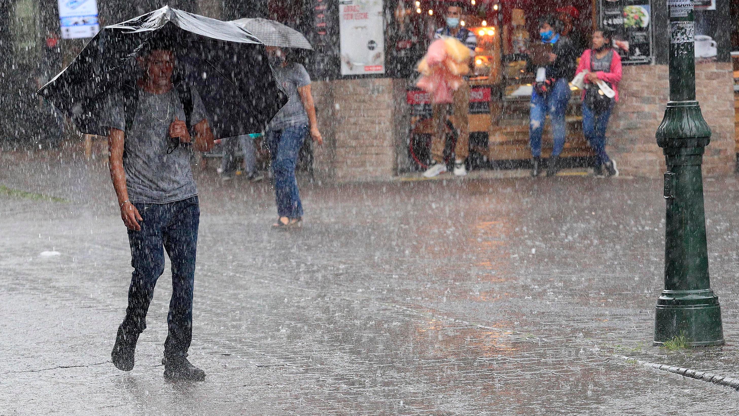 28/09/2021 San José. Fuerte aguacero cayó la tarde de este martes en la cpaital. Muchas personas recurrieron a sus sombrillas y paraguas para protegerse de las fuertes lluvias, detrás del Banco Central