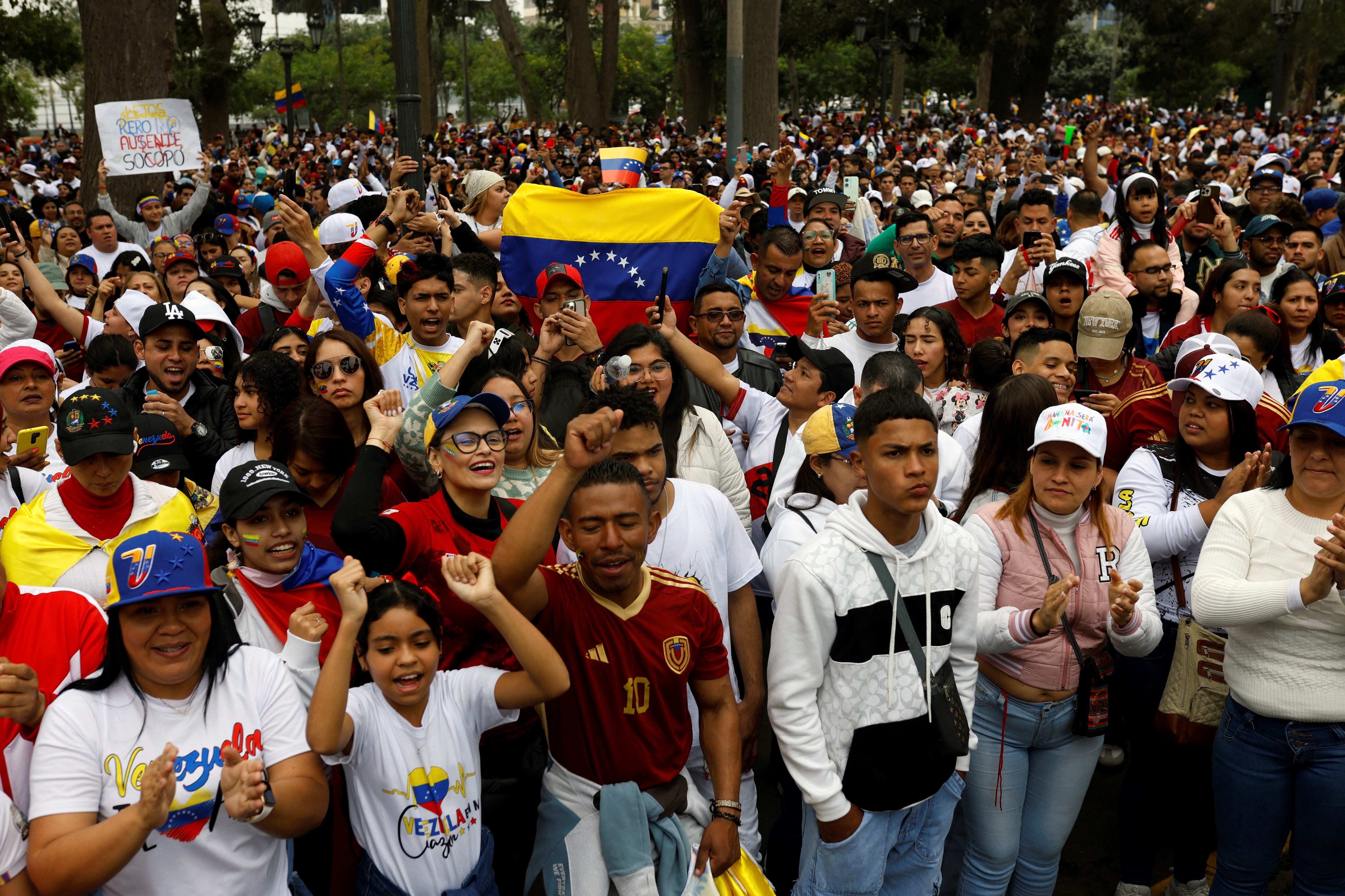 Venezolanos residentes en Perú y opositores del presidente venezolano Nicolás Maduro esperan los primeros resultados de las elecciones presidenciales afuera de la embajada de Venezuela.