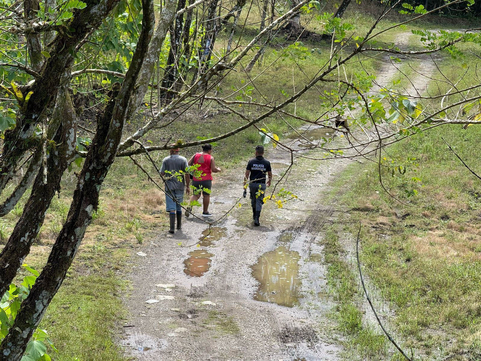 Oficial de Migración con migrantes en los caminos externos del CATEM en la zona sur.