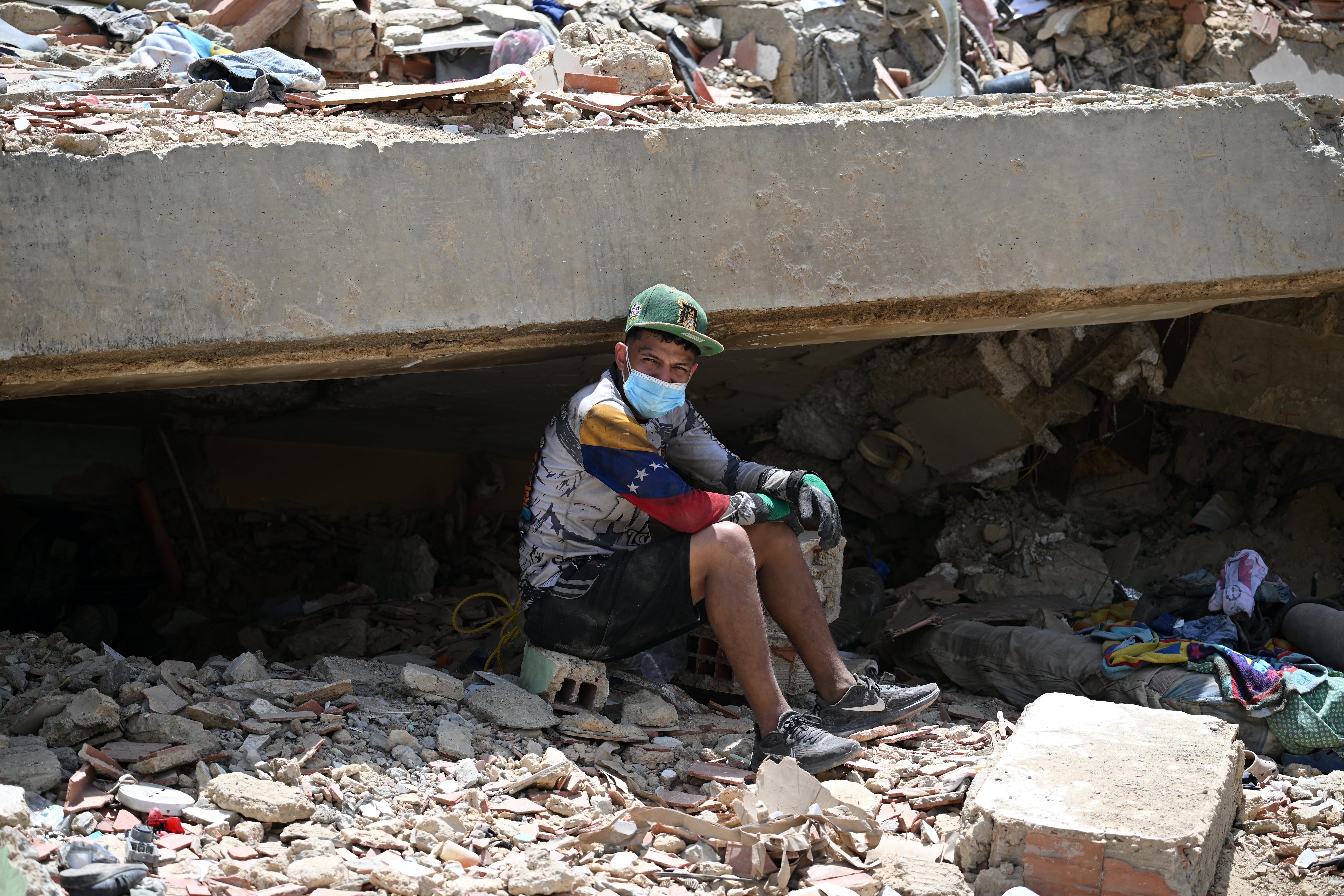 Un sobreviviente descansa sobre las ruinas, esperando ayuda internacional y local para reconstruir su vida.