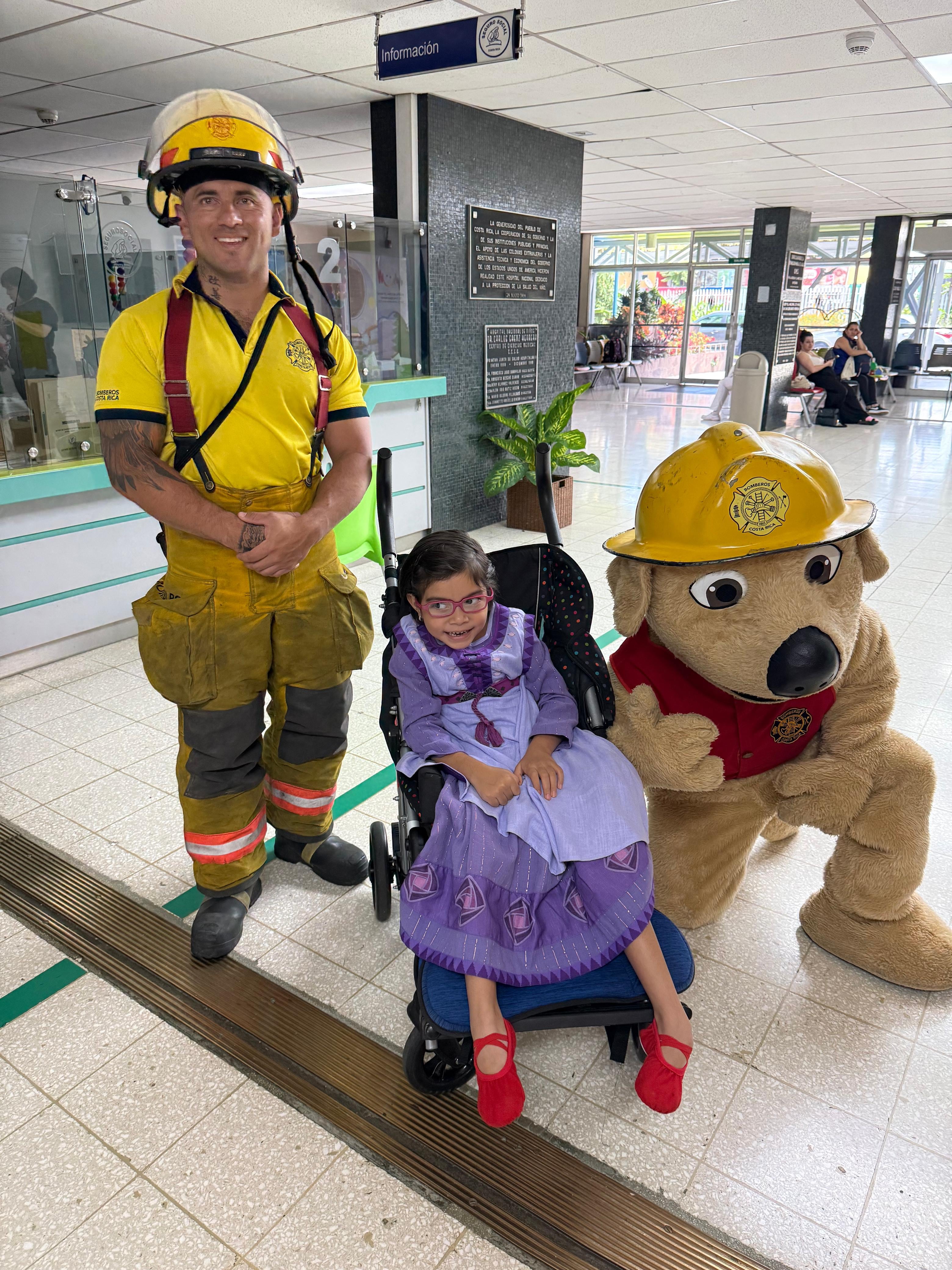 Celebración del Día del Niño 2025 en el Hospital de Niños.En la foto, la niña Victoria Rivera, junto al bombero Pablo Herrera y la mascota del Cuerpo de Bomberos, Jack.