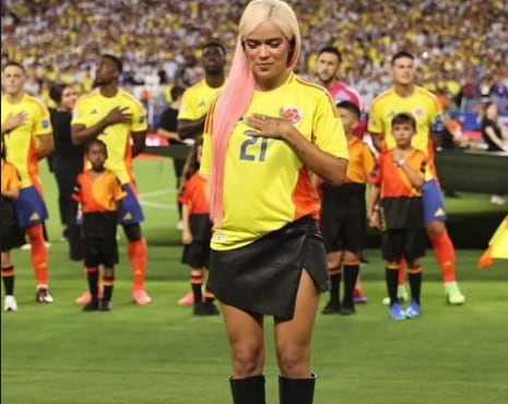 Karol G y otras cantantes cantando el himno nacional de su país