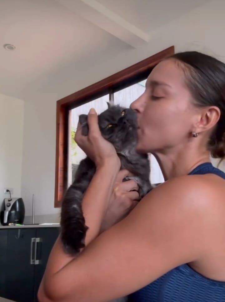 Paola Chacón besando a su gato.