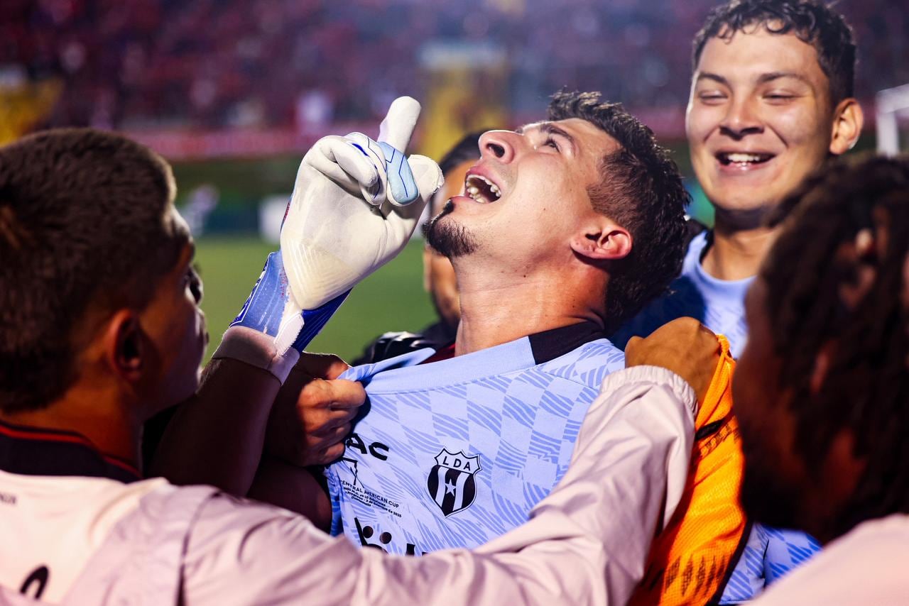 पेनल्टी शूटआऊटमधील त्याच्या निर्णायक कामगिरीनंतर लीगा डेपोर्टिव्हा अलाजुएलेन्सचा गोलरक्षक बायरन मोरा उत्सव साजरा करत आहे ज्याने लाल आणि काळ्या संघाला झेलाजू विरुद्ध सेंट्रल अमेरिकन कप विजेतेपद मिळवून दिले.