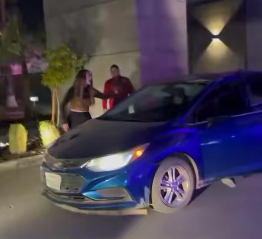 La mujer golpeó el parabrisas de un carro azul tras una supuesta infidelidad.