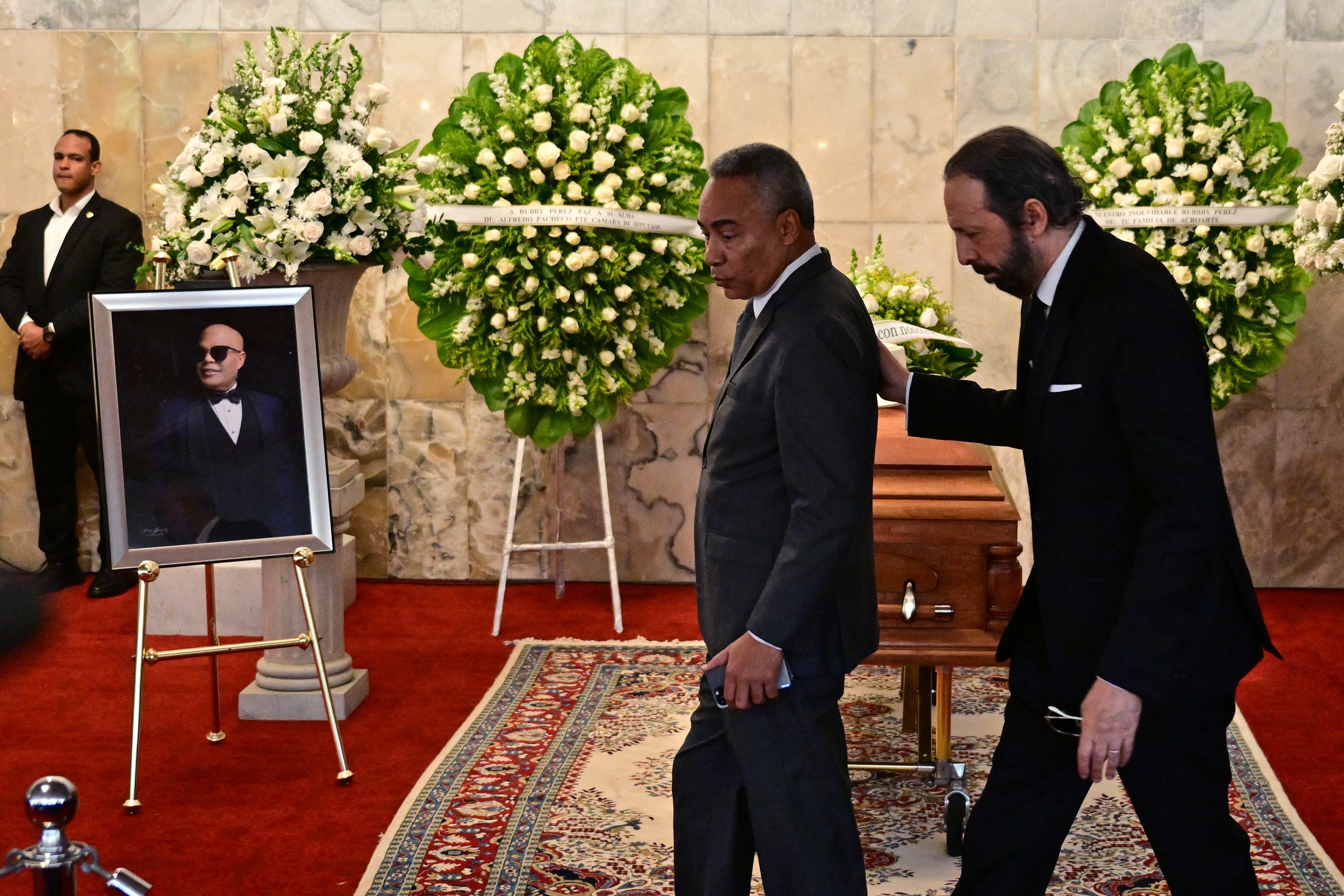 El cantante y compositor dominicano Juan Luis Guerra (der.) y el periodista dominicano Severo Rivera asisten al velatorio del famoso merenguero Rubby Pérez, quien falleció tras el derrumbe del techo de la discoteca Jet Set donde se presentaba, en el Teatro Nacional de Santo Domingo.