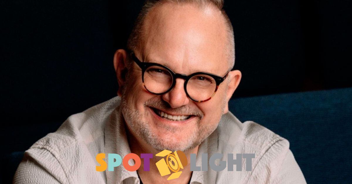 Imagen en primer plano del cantante cristiano Marcos Witt.  Usa lentes, una camisa negra y una sobre camisa de color gris claro.  Sonríe.