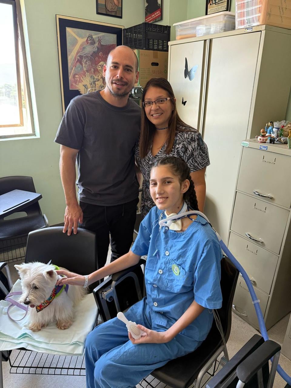 Un perro de terapia en la sala de cuidados intensivos, una joven paciente y sus padres.
