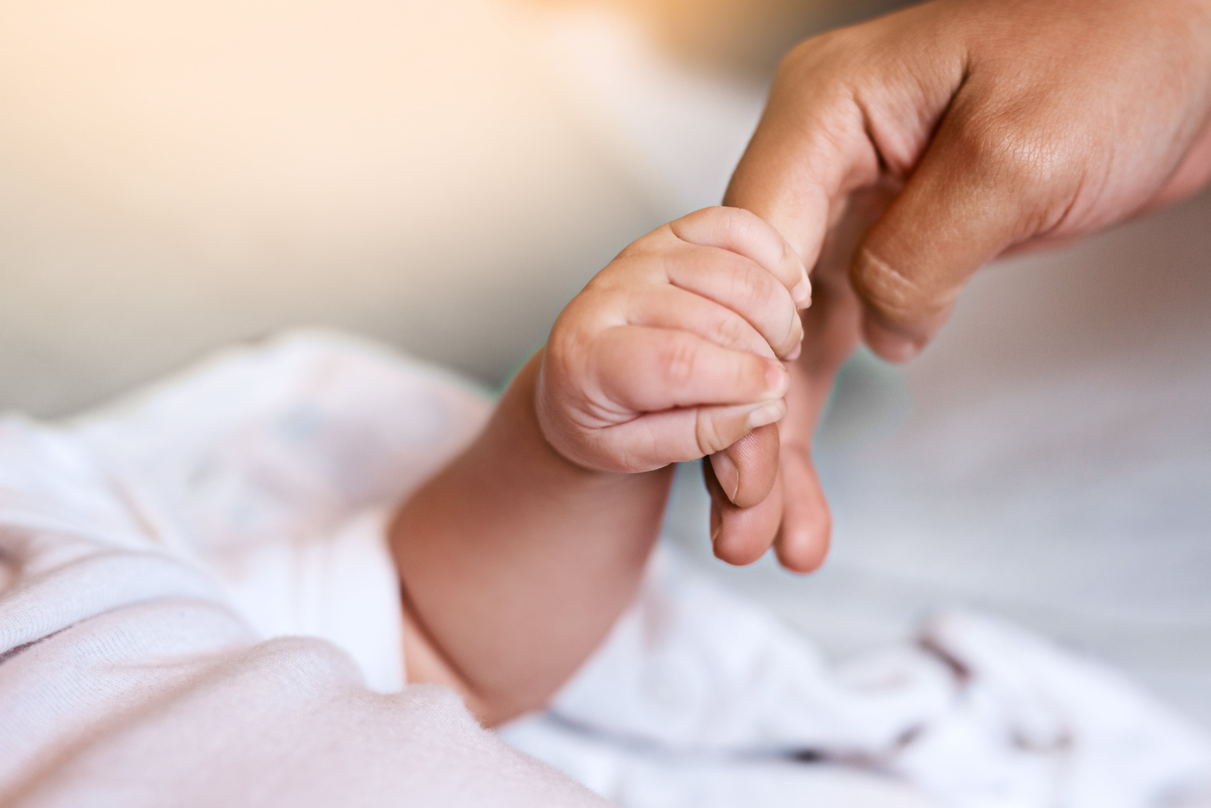 Mano de bebé recién nacido con una mano adulta