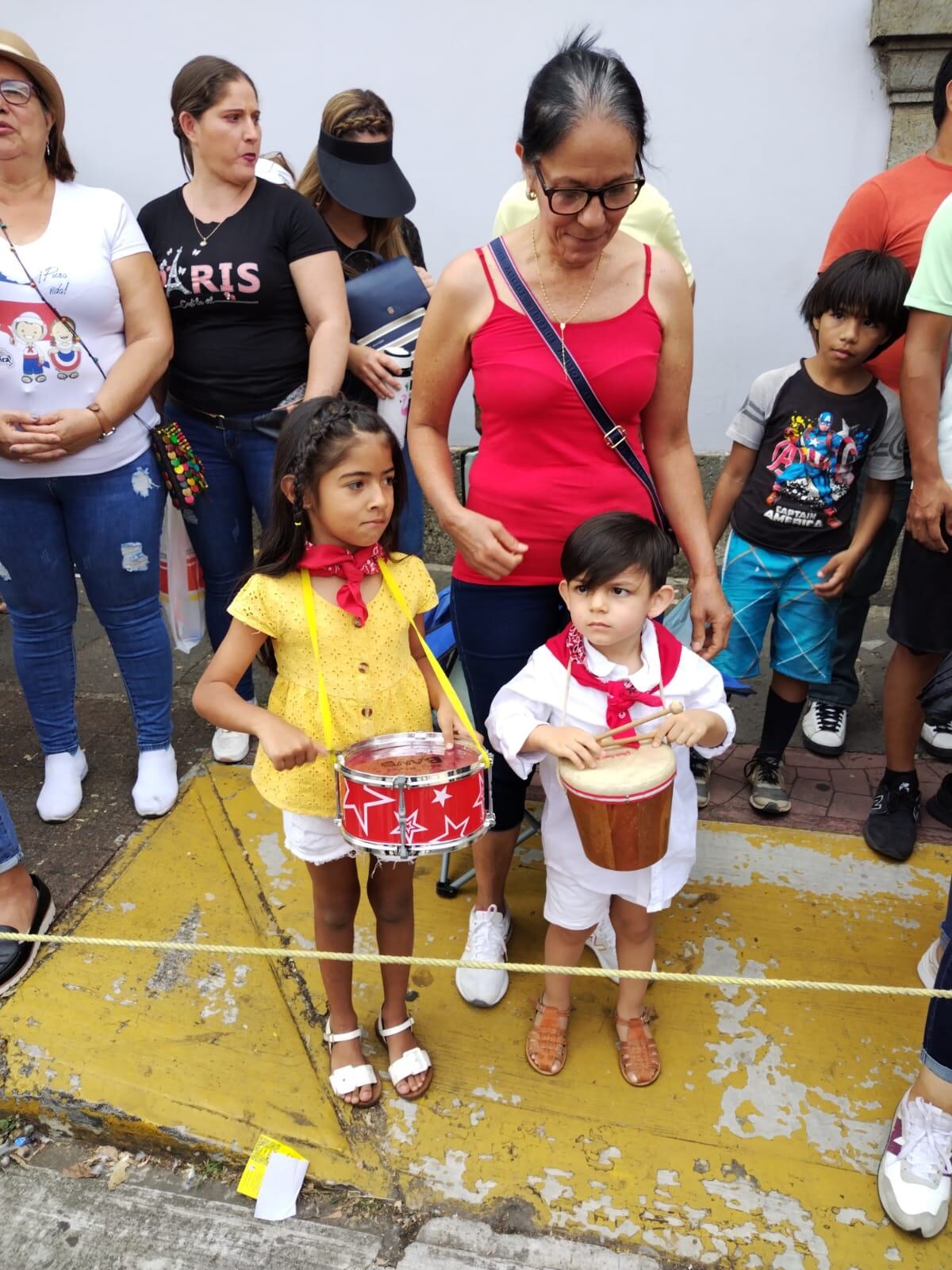 El 11 de abril del 2023, en Alajuela, se conmemoraron los 167 años de la Batalla de Rivas, en la cual destacó la gesta heroica de Juan Santamaría. Los actos fueron en el parque Juan Santamaría y hubo desfile en las calles alajuelenses. En la foto Luciano Vega con el tamborcito, Isabella Ávila con otro tamborcito rojo y la abuela Juanita Rojas.